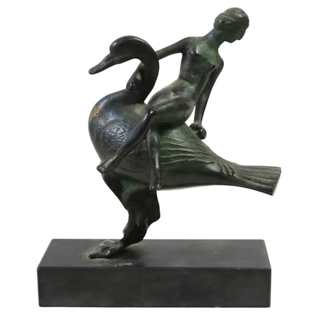 A STYLIZED PATINATED BRONZE GROUP depicting a female figure ...