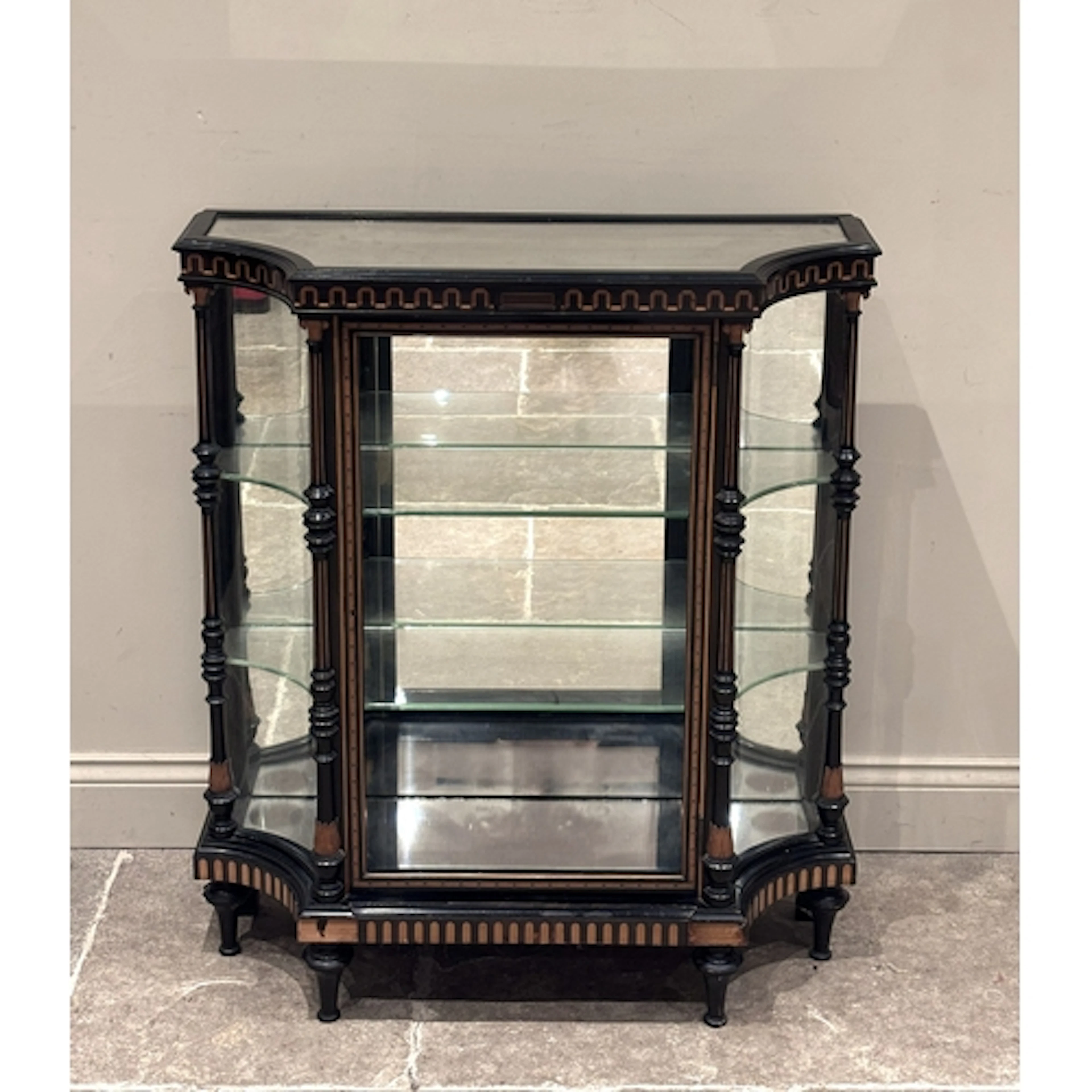 A Victorian ebonised vitrine by Howard & Sons, the mirrored ...