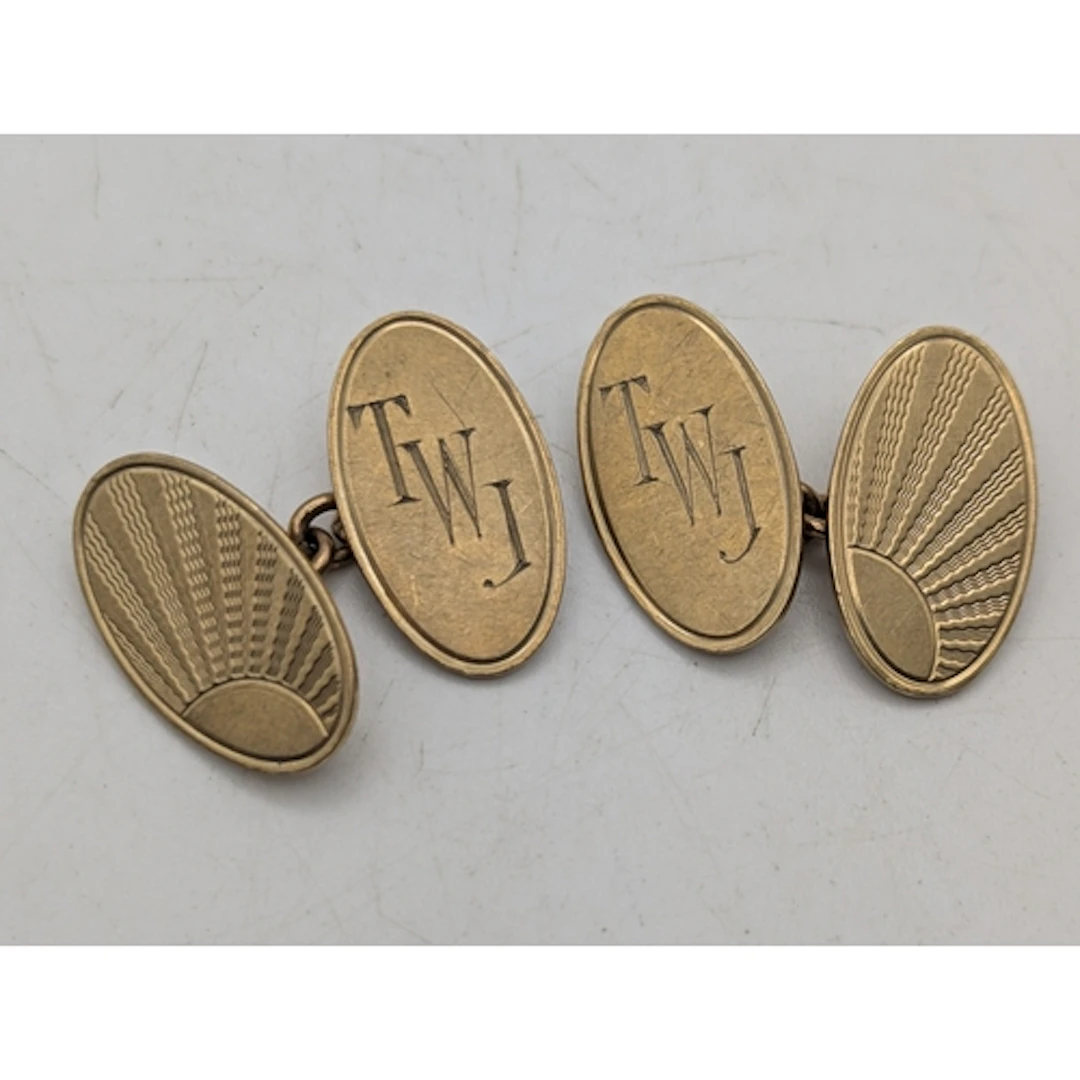 A pair of 9ct yellow gold oval shaped cufflinks, having engi...