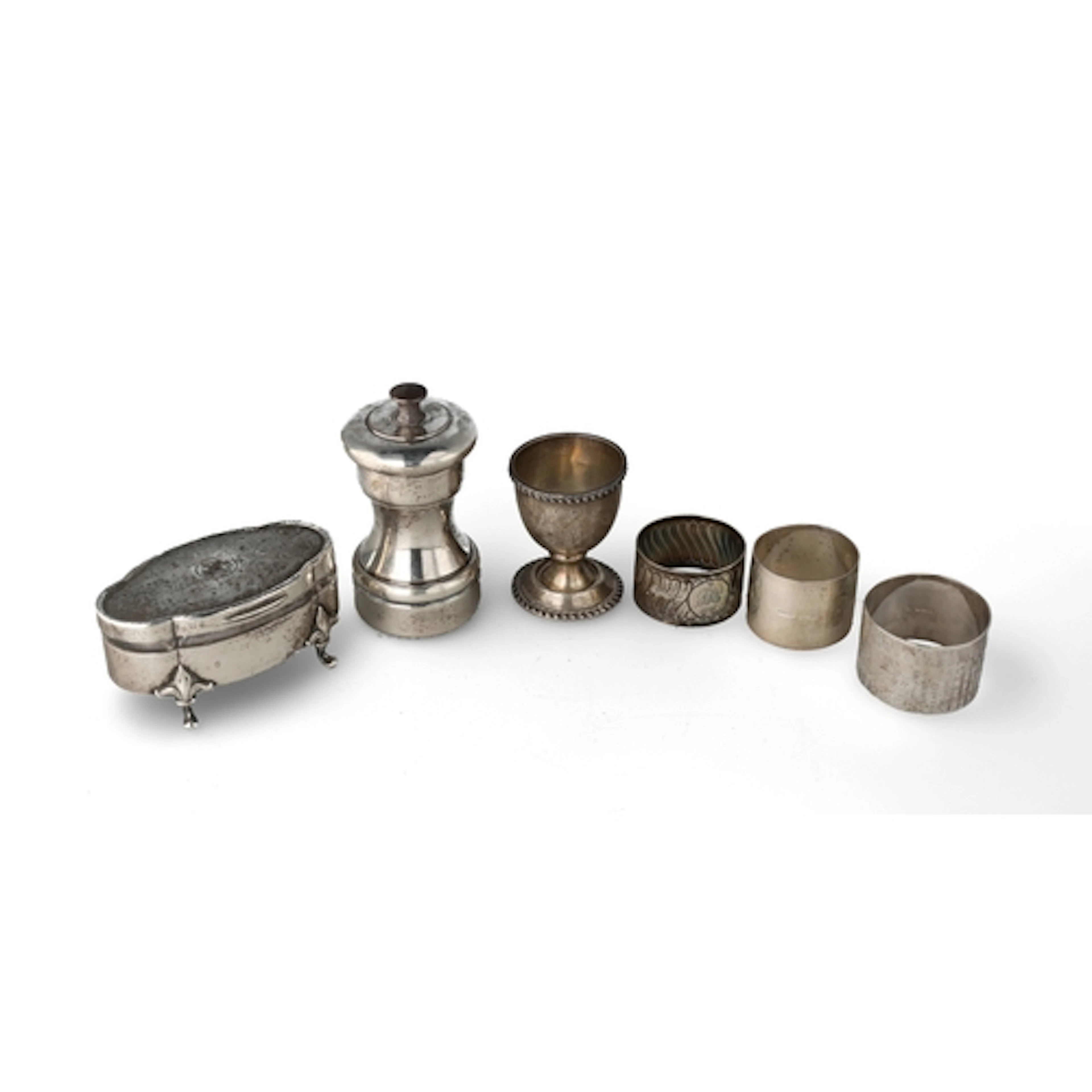 A SILVER TRINKET BOX, THREE NAPKIN RINGS, SILVER MOUNTED PEP...