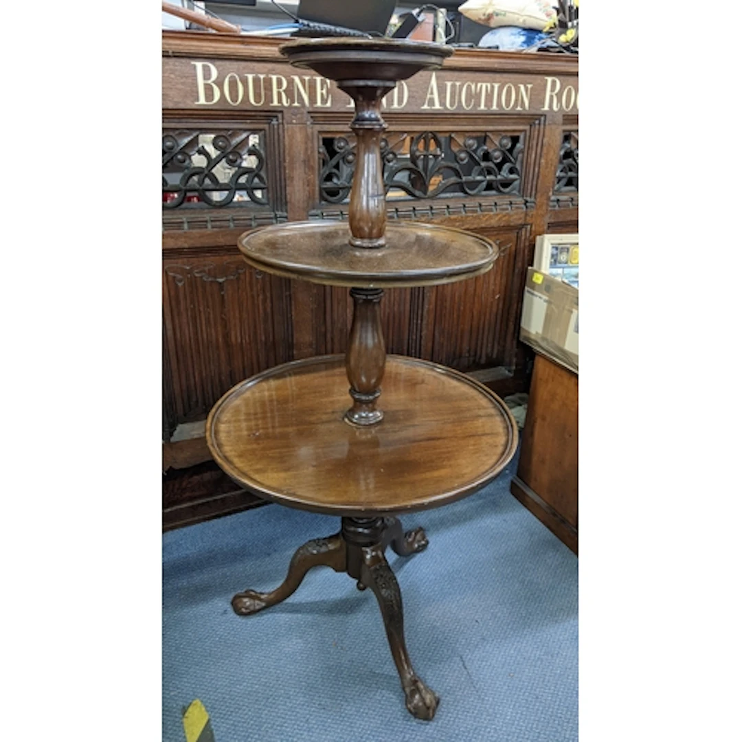 A 19th century mahogany three tier dumb waiter on cabriole l...