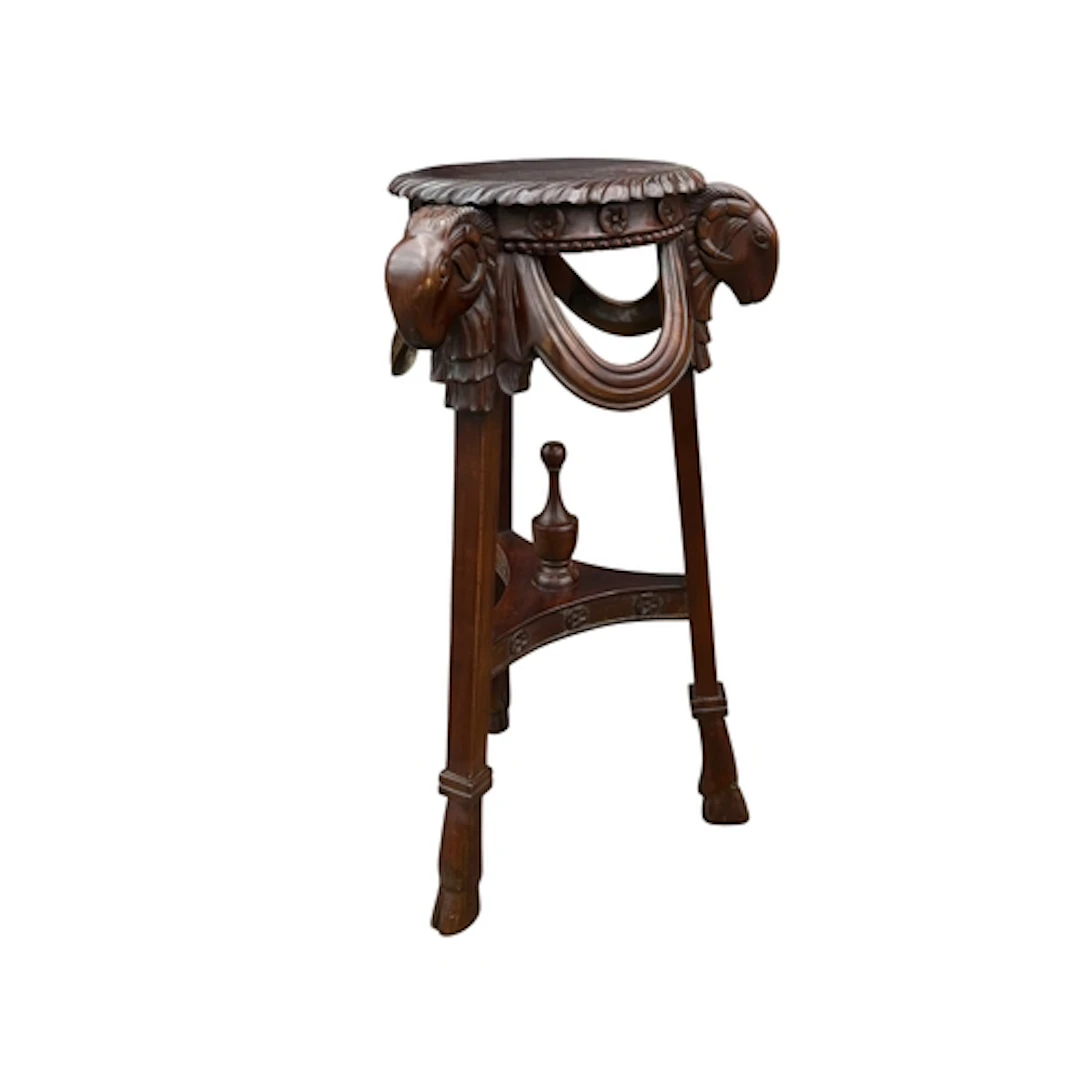 A THREE-LEGGED JARDINIERE STAND With rams head finials and h...