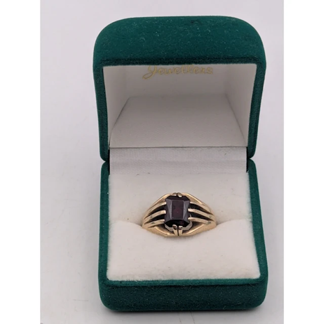 A 9ct yellow gold and garnet ring, featuring an emerald cut,...