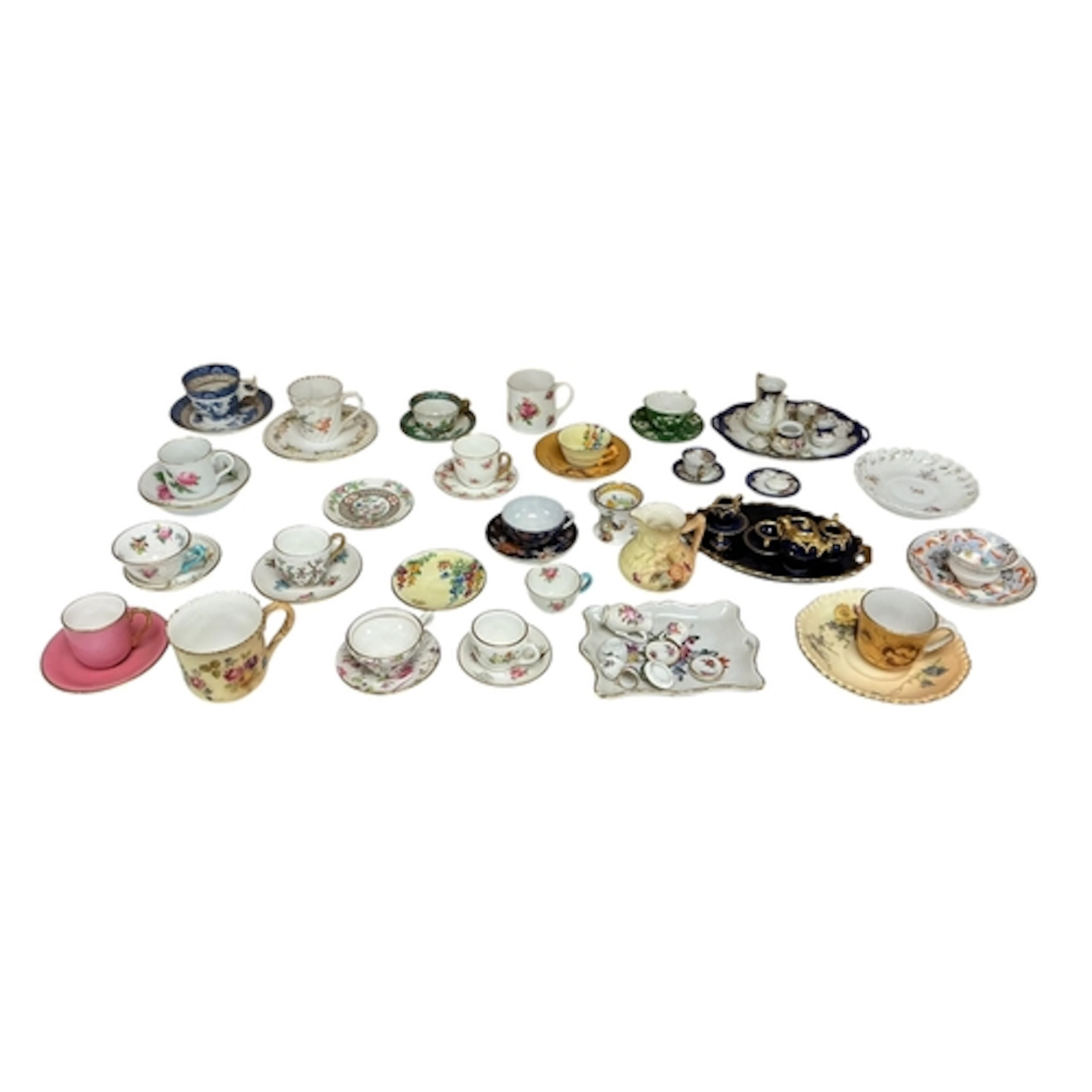 A collection of miniature tea ware, trays, cups and saucers ...