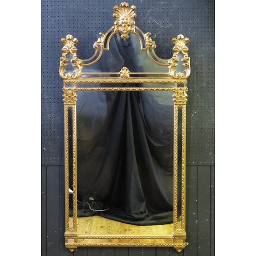A gilt wood pier glass, of arched outline with scroll and fo...