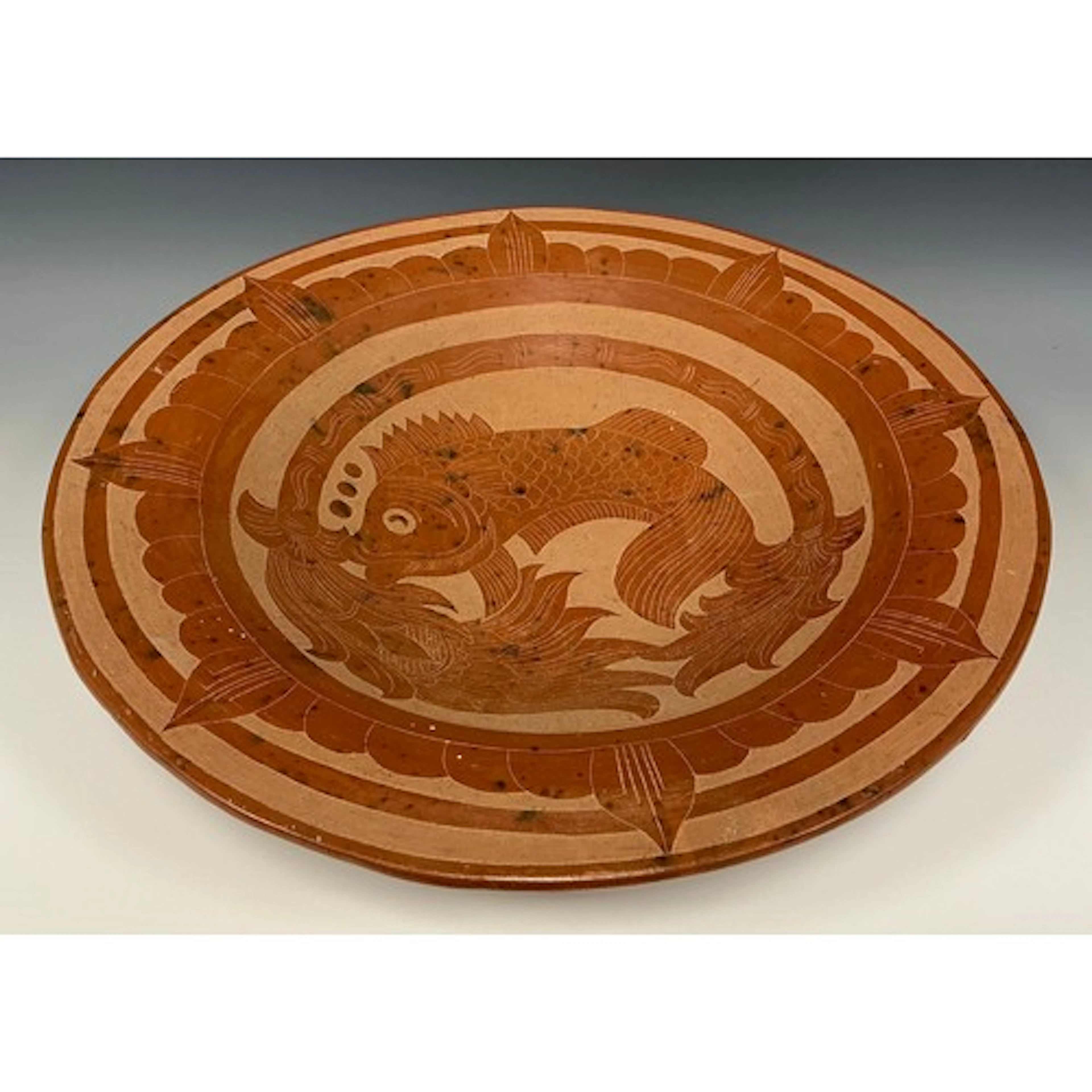 A large Arts & Crafts terracotta dish, incise decorated with...