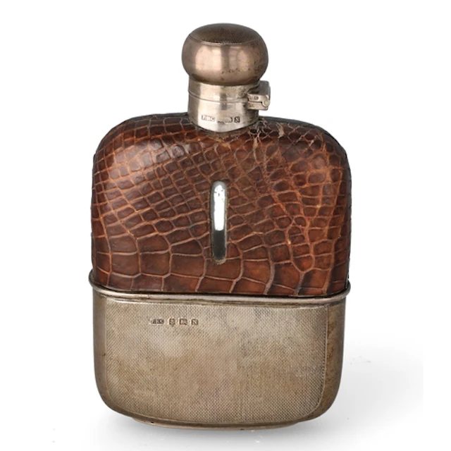 AN ART DECO SILVER MOUNTED GLASS AND CROCODILE SPIRITS FLASK...