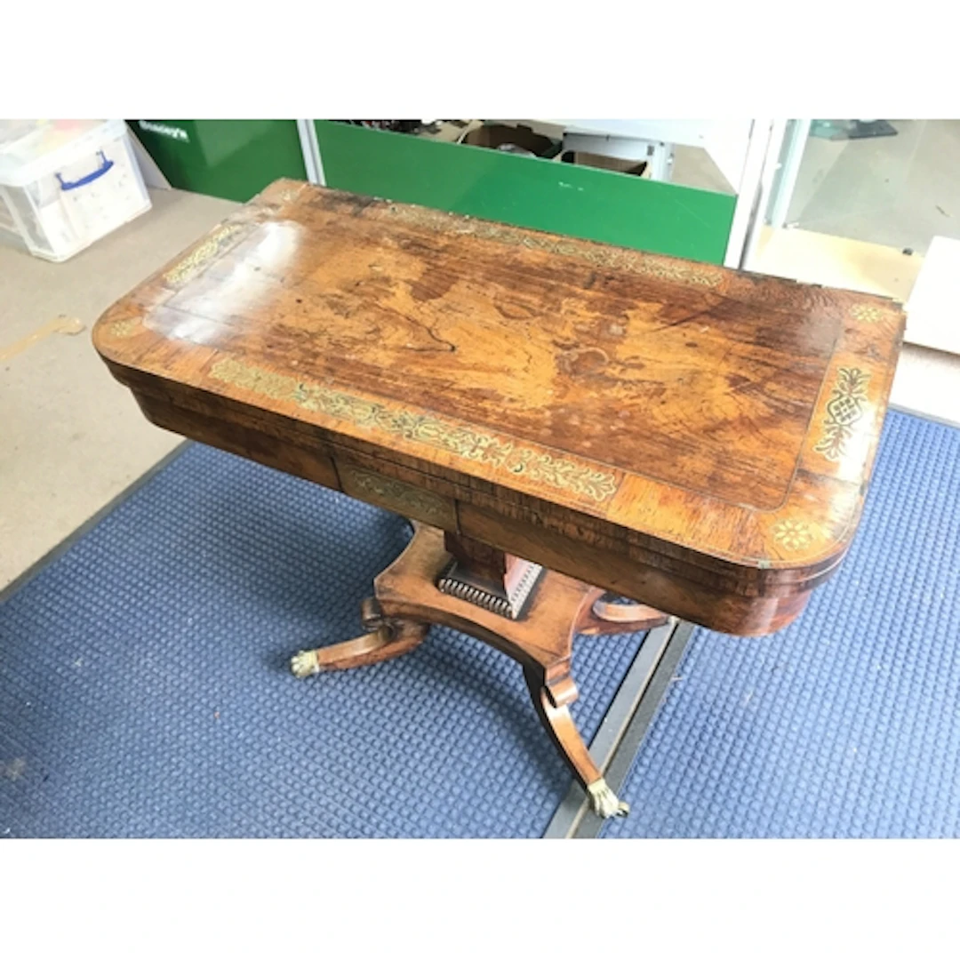 A rosewood veneered card table with brass inlay. In need of ...