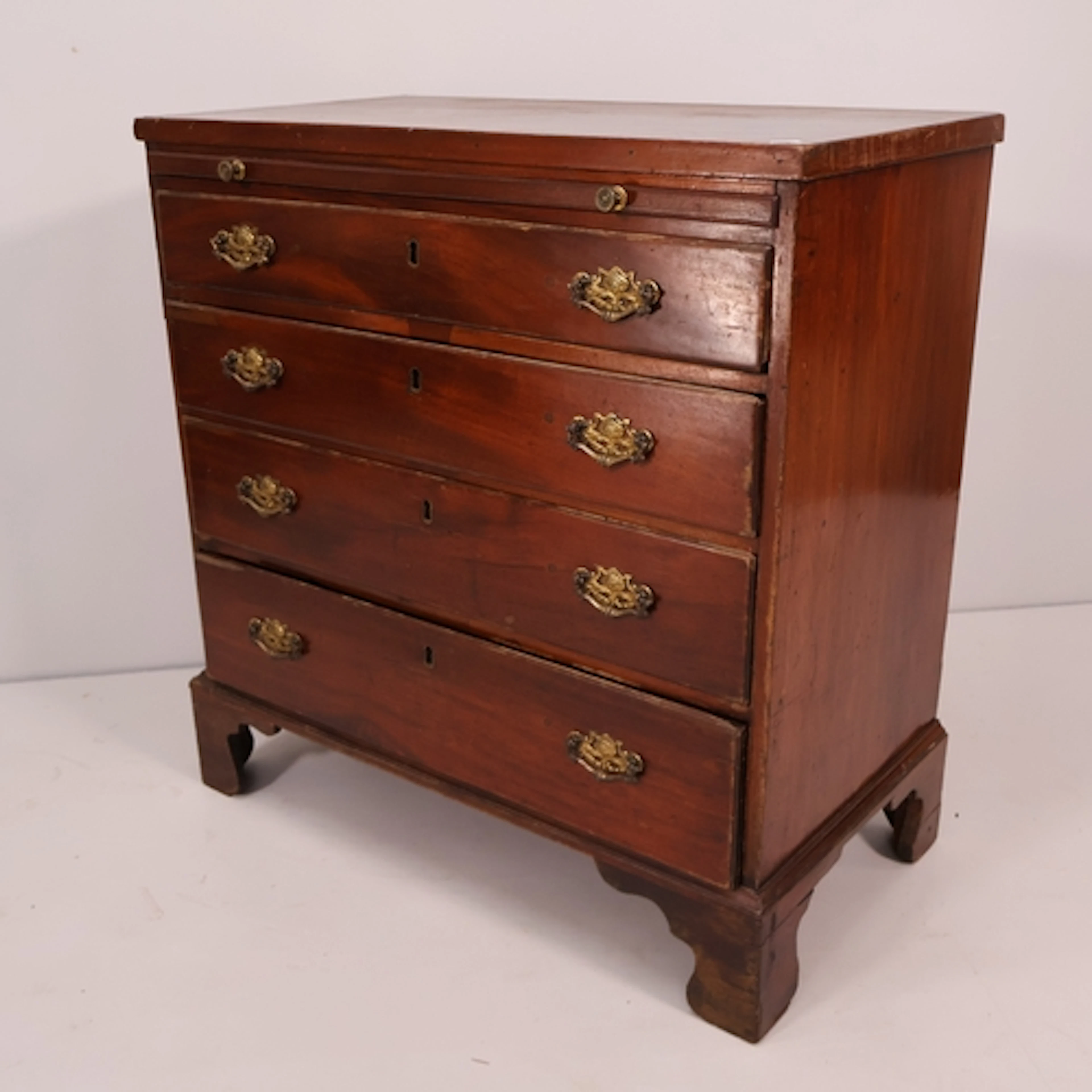 An antique mahogany bachelor's chest, brushing slide with fo...
