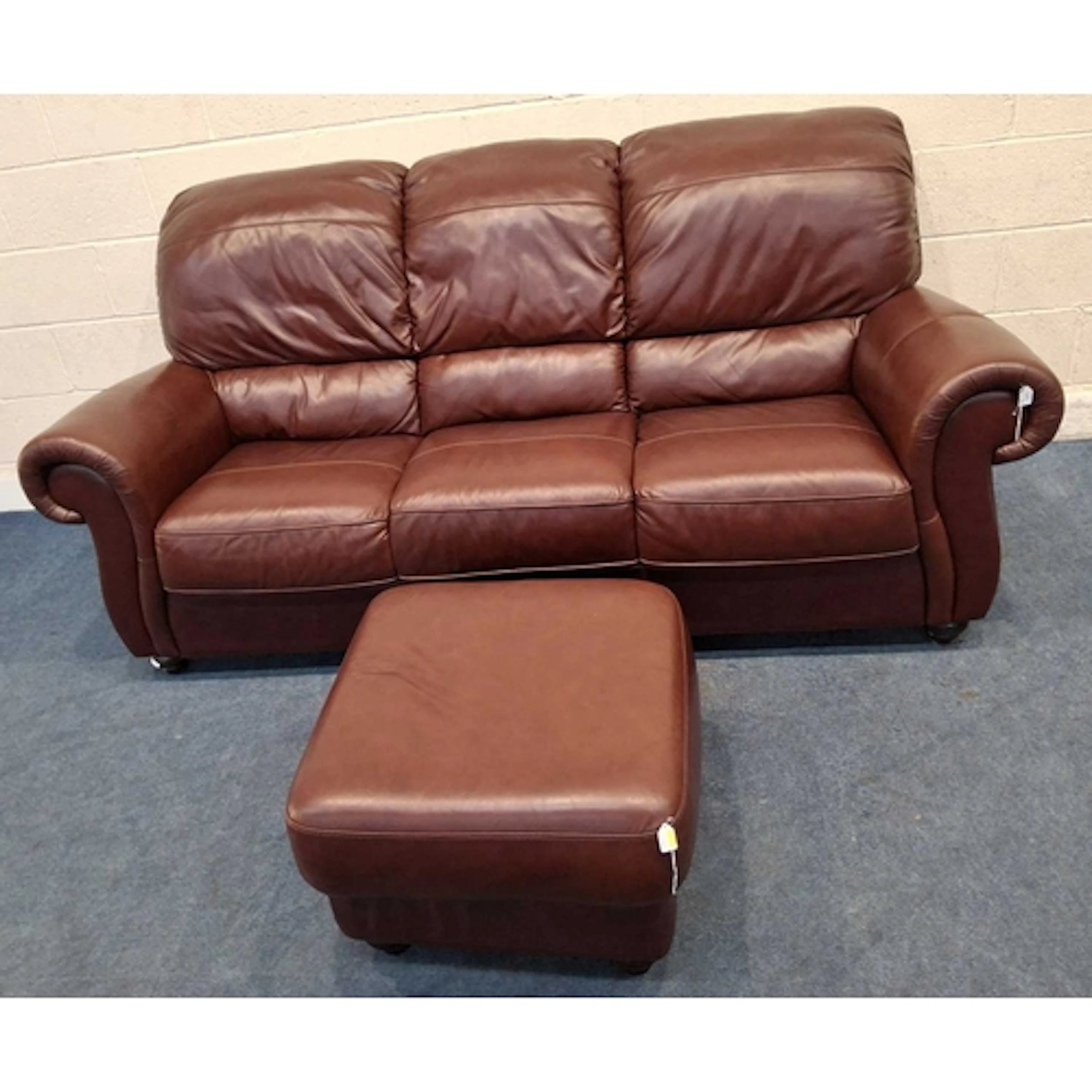 A BURGUNDY LEATHER THREE SEATER SOFA, along with a matching ...