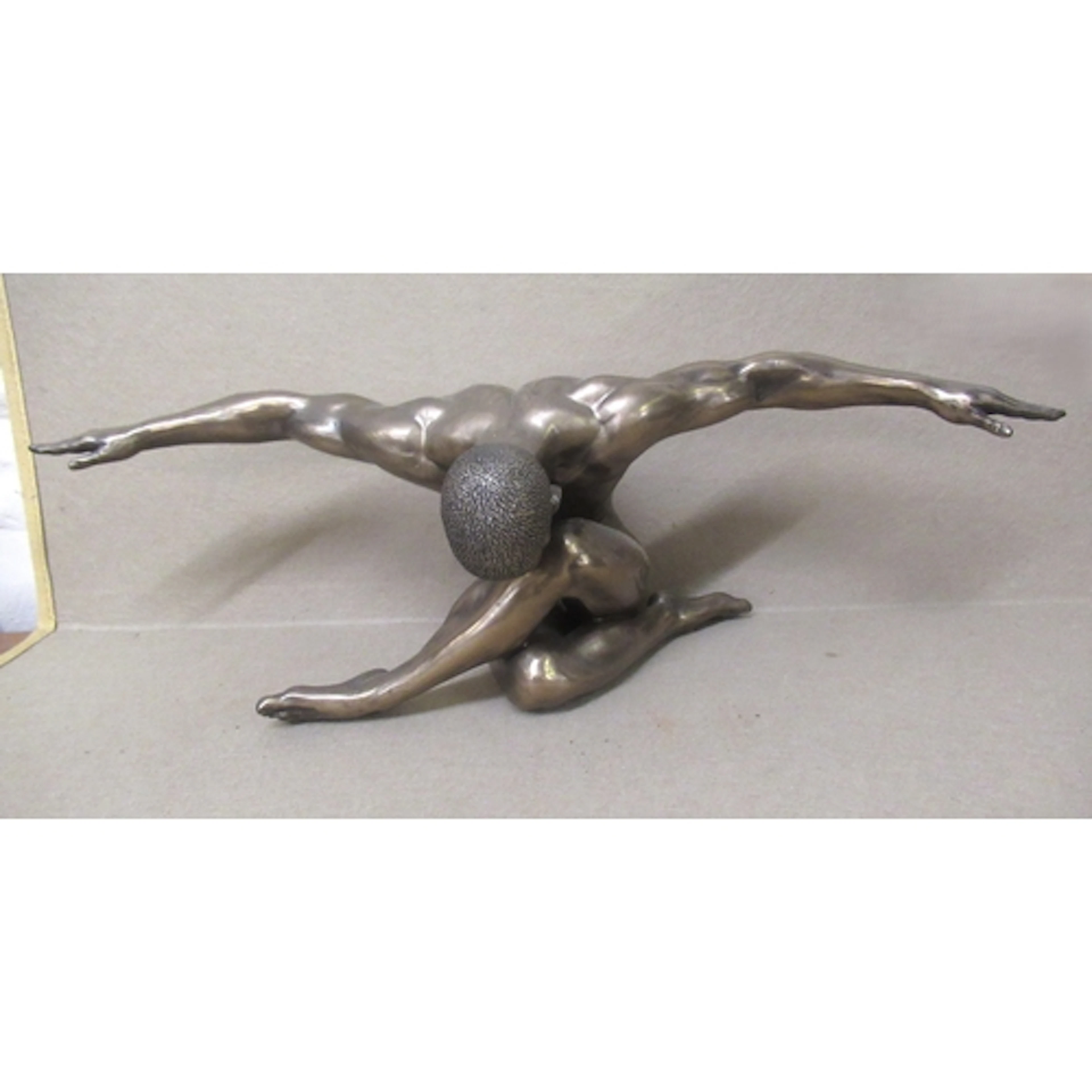 Bronzed composition of a seated figure with arms outstretche...
