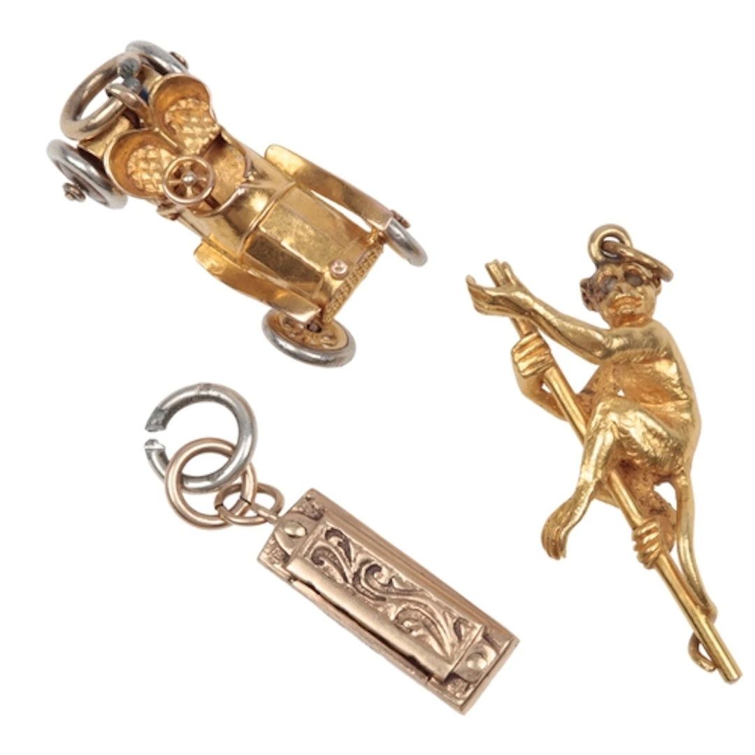 Three gold charm pendants, early-mid 20th century, comprisin...