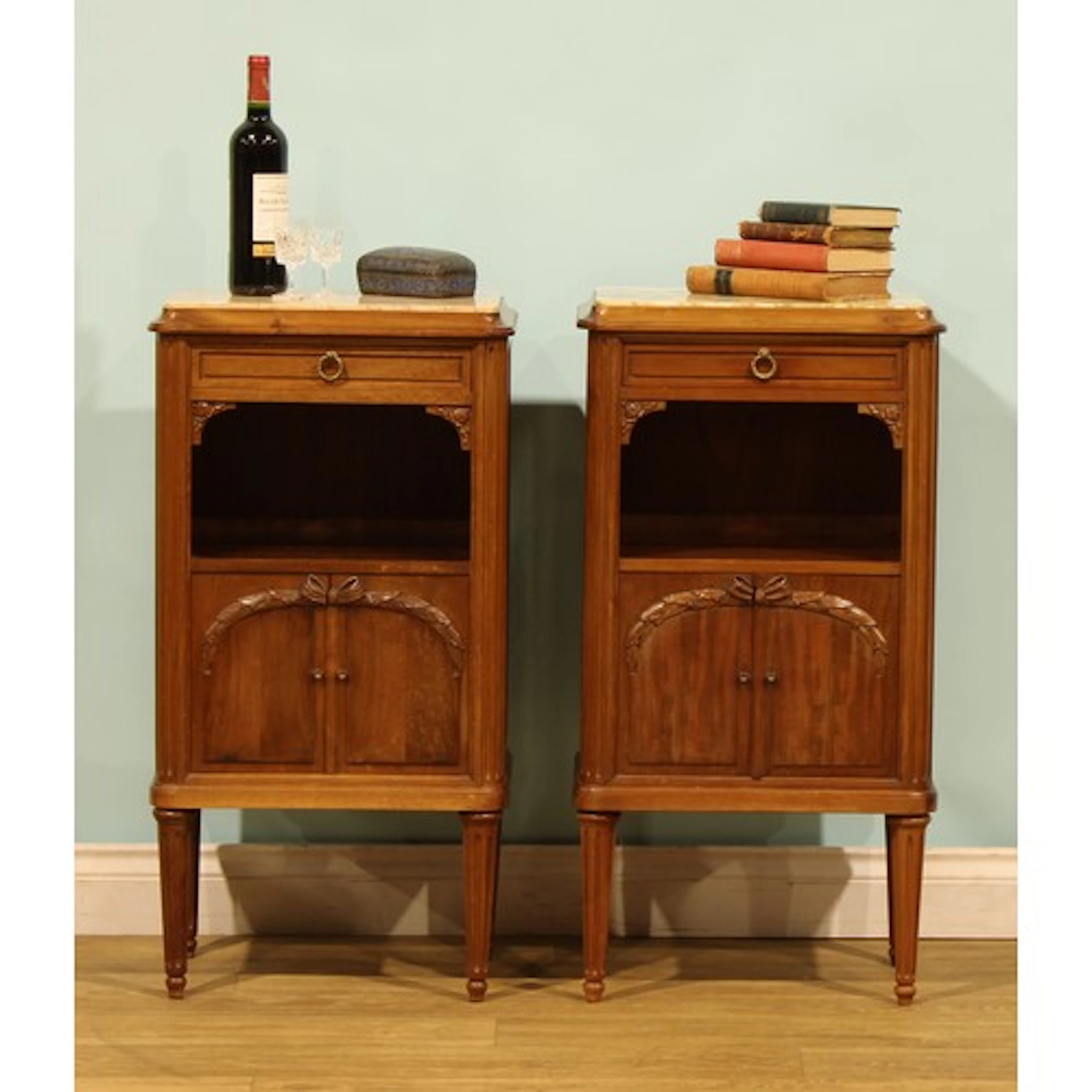 A pair of French mahogany tables de chevet, each with a marb...