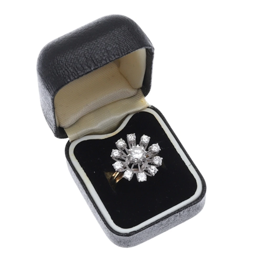 A DIAMOND AND 18CT GOLD CLUSTER RING. of stylised flowerhead...