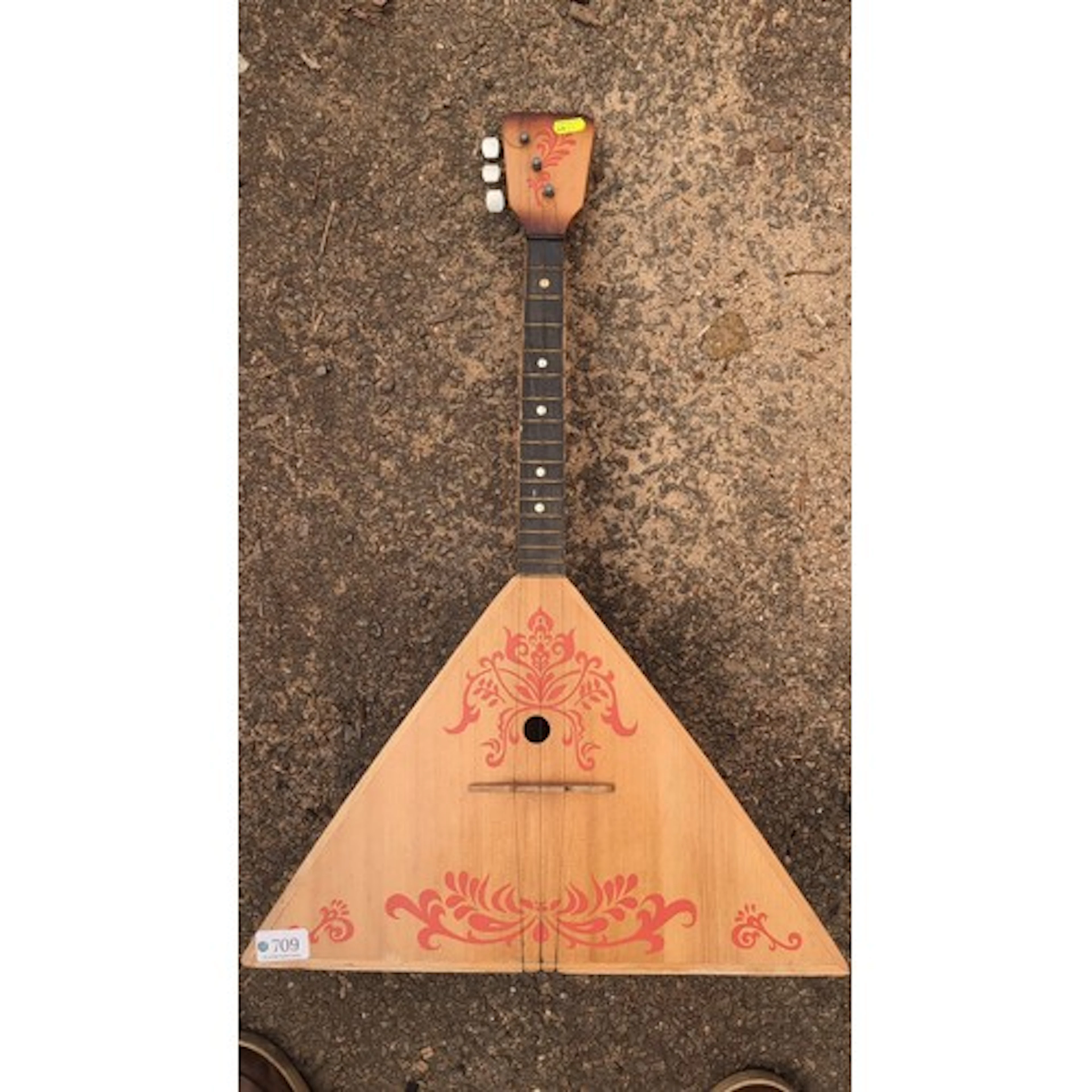 A triangular-bodied Russian-style balalaika, with three stri...