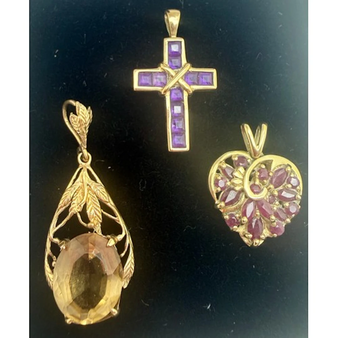 Three 9 carat gold gem set pendants to include crucifix and ...