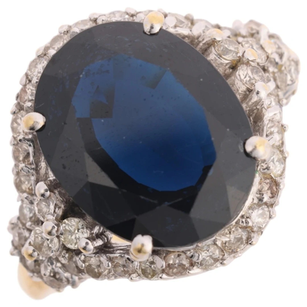 An 18ct gold sapphire and diamond cluster ring, claw set wit...