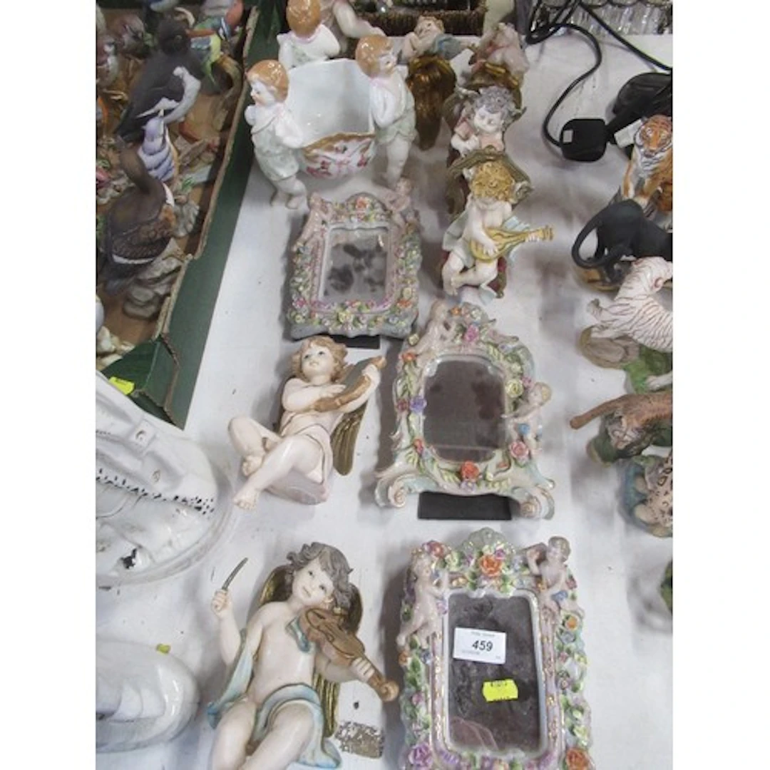 A collection of continental cherub models including mirrors