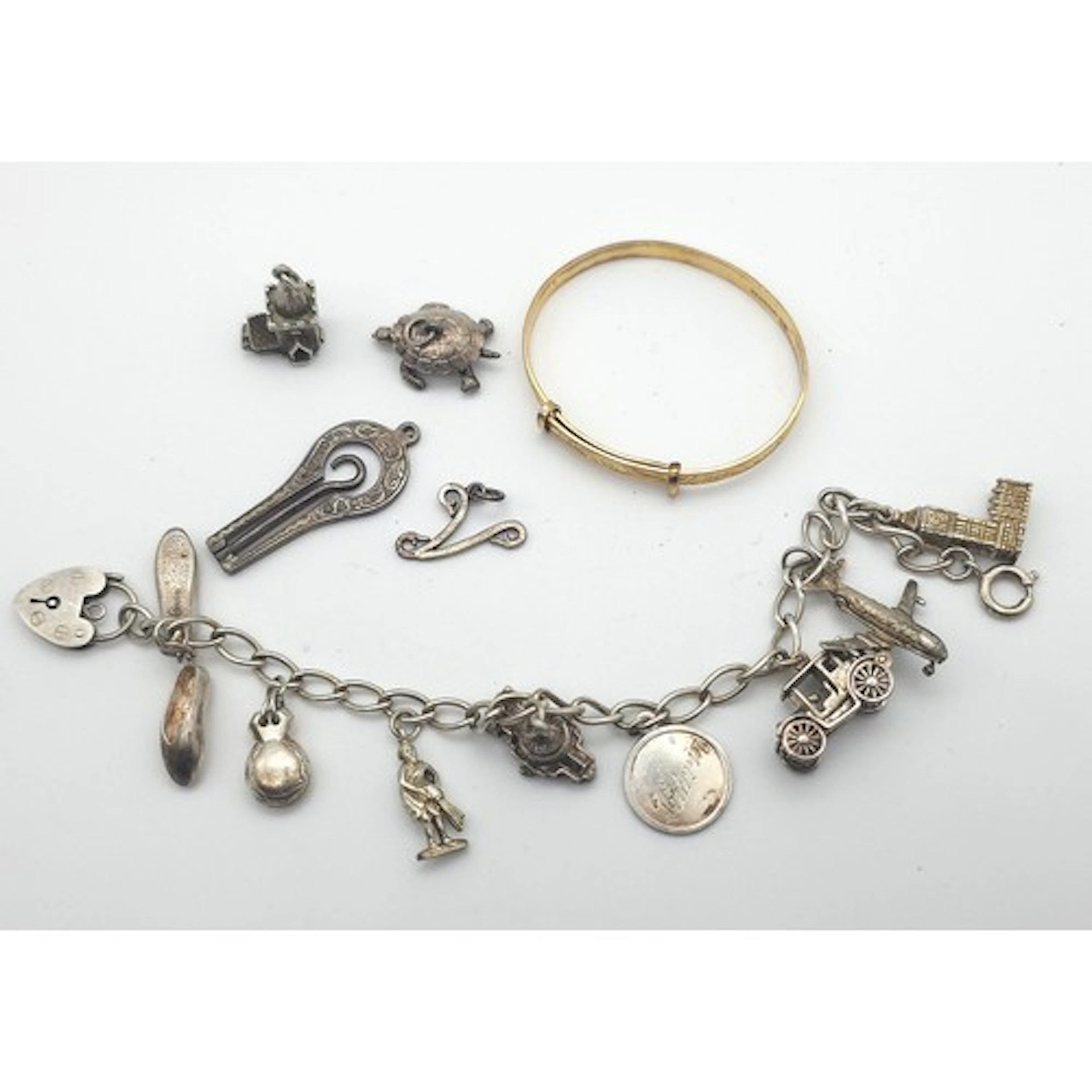 A silver charm bracelet, with heart-shaped padlock clasp, su...