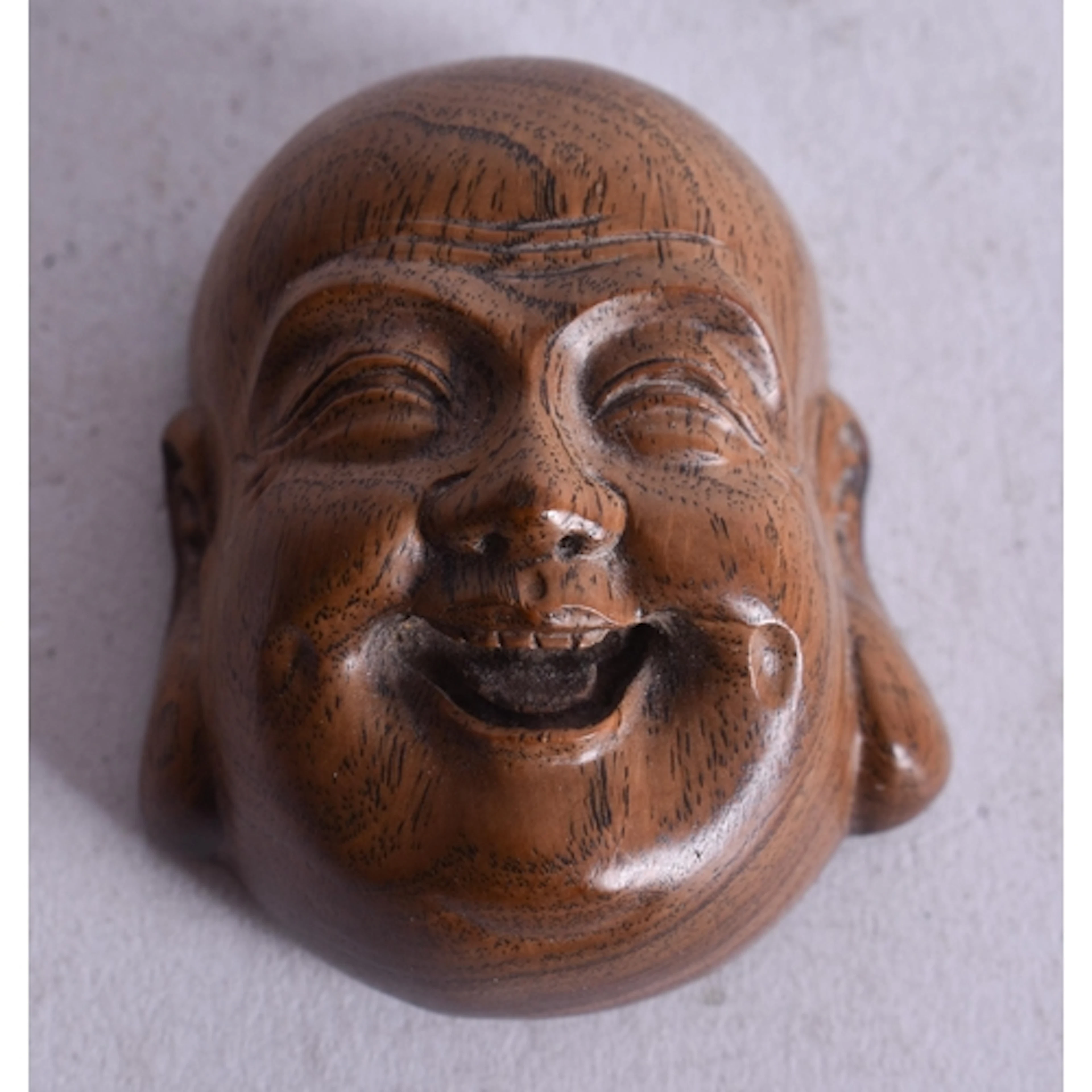 A JAPANESE CARVED WOOD MASK NETSUKE. 4 cm x 3.5 cm.