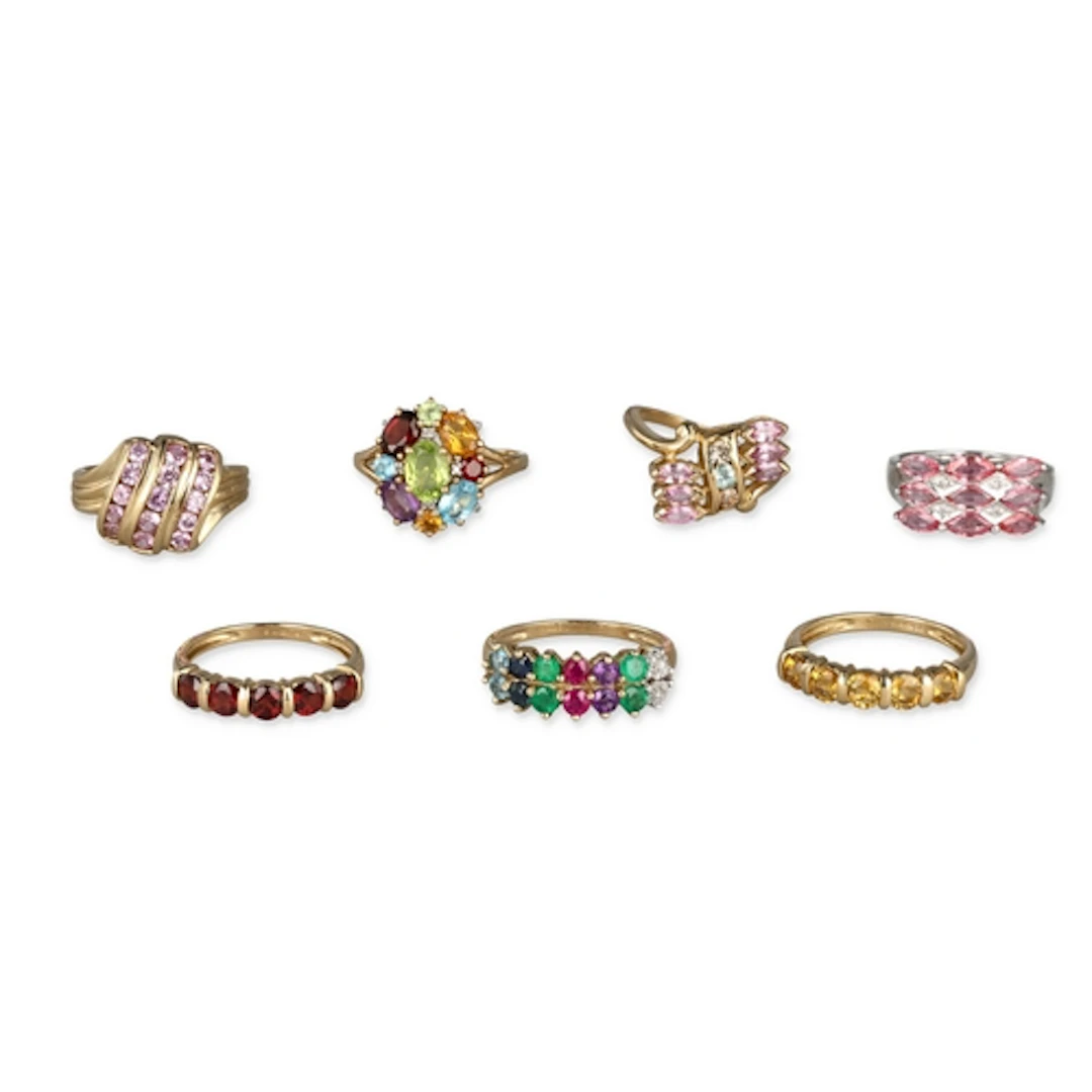 SEVEN NINE CARAT GOLD RINGS SET WITH VARIOUS COLOURED GEMSTO...