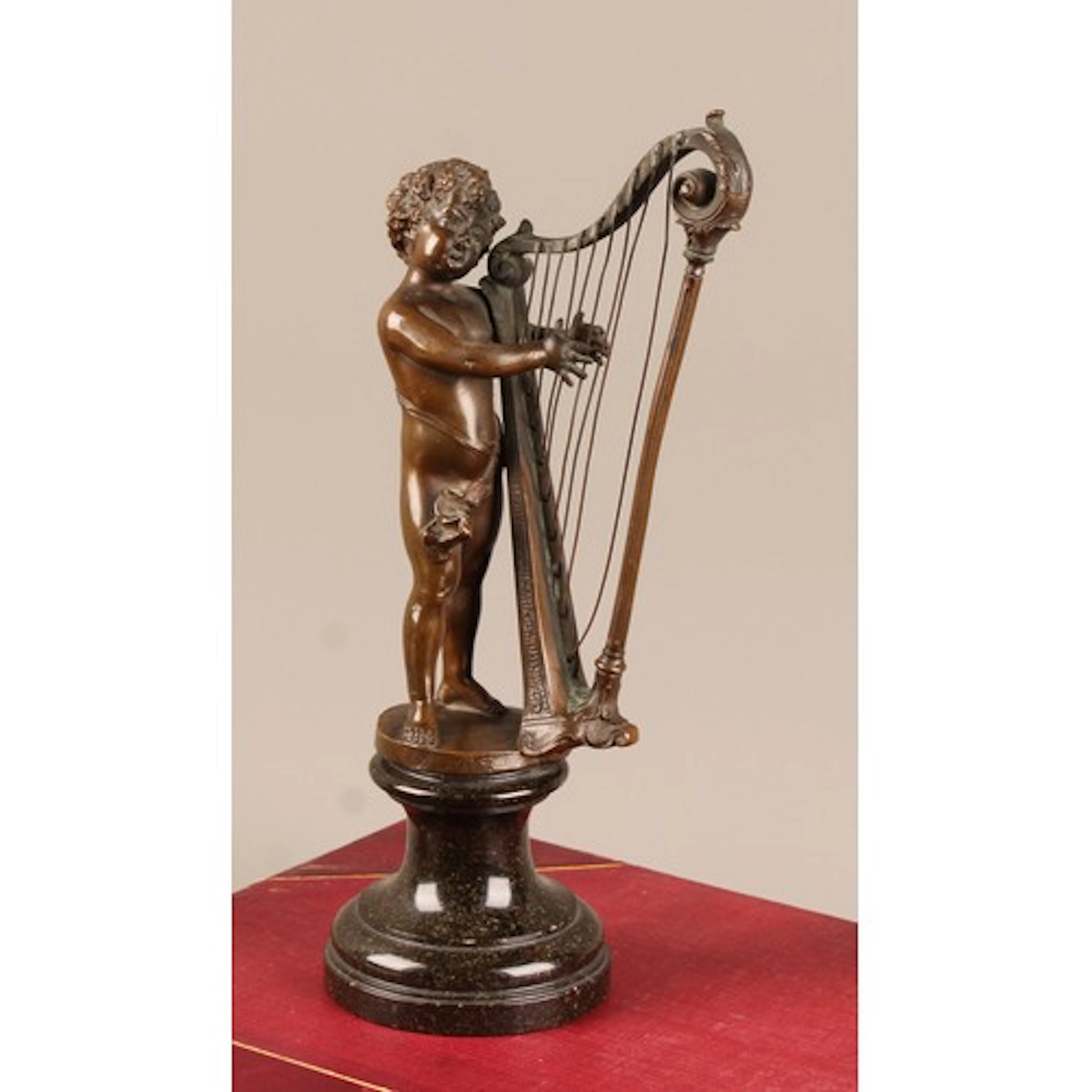 A 19th century Continental patinated bronze, as a putto play...