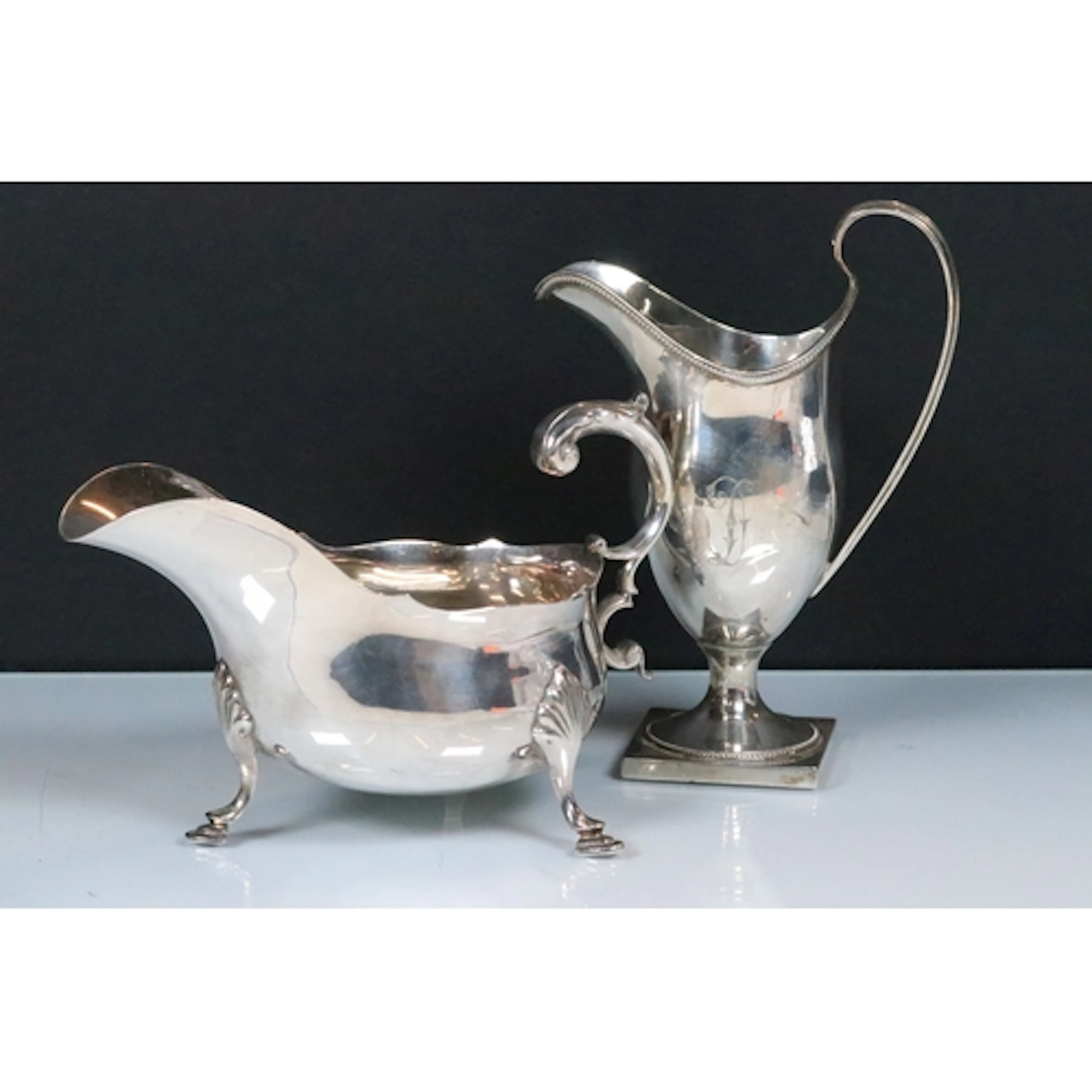 Two silver jugs to include a Henry Aitkin jug with shaped ri...