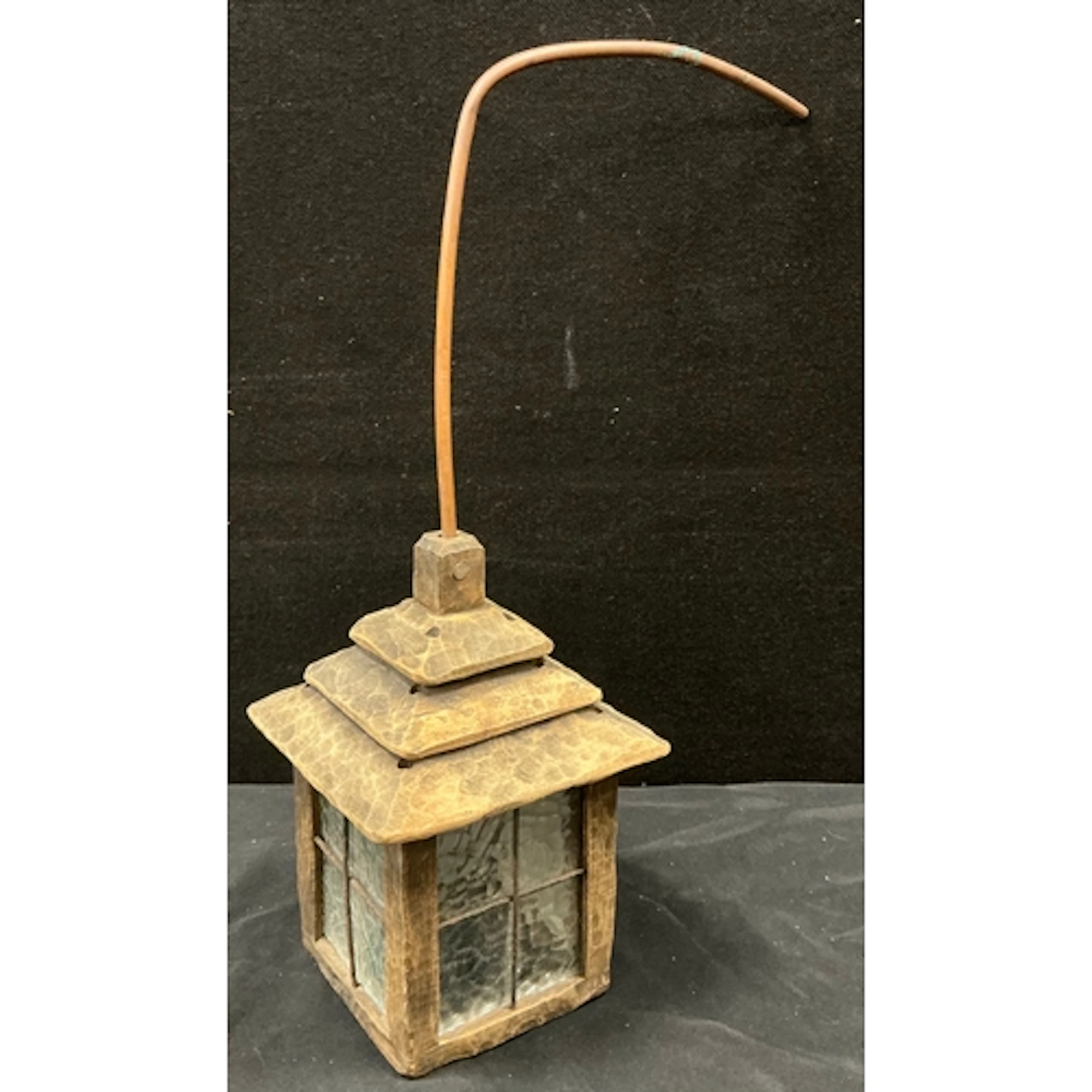 A hand carved lantern featuring a three tiered pagoda style ...