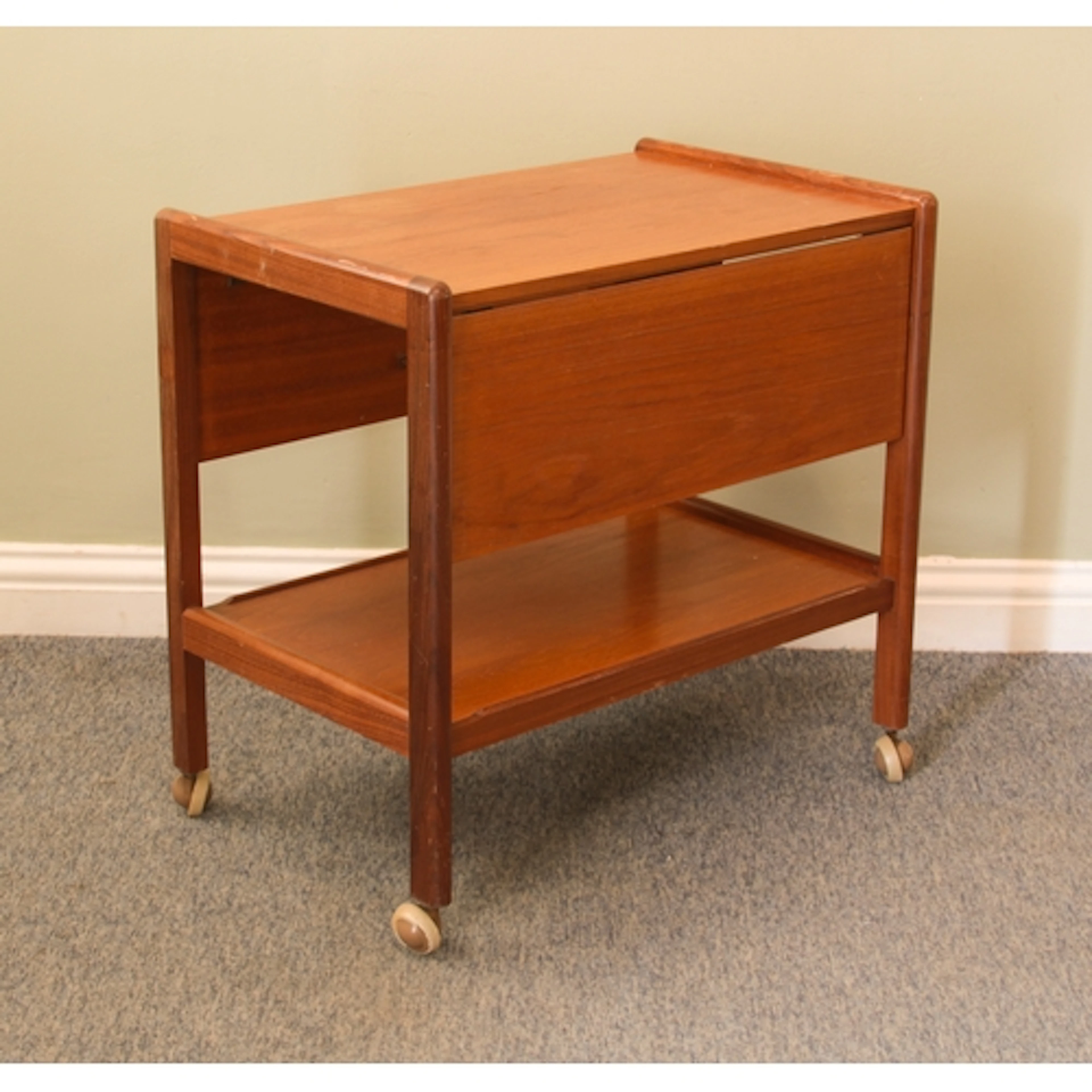 A vintage teak two-tier drinks or serving trolley with a dro...