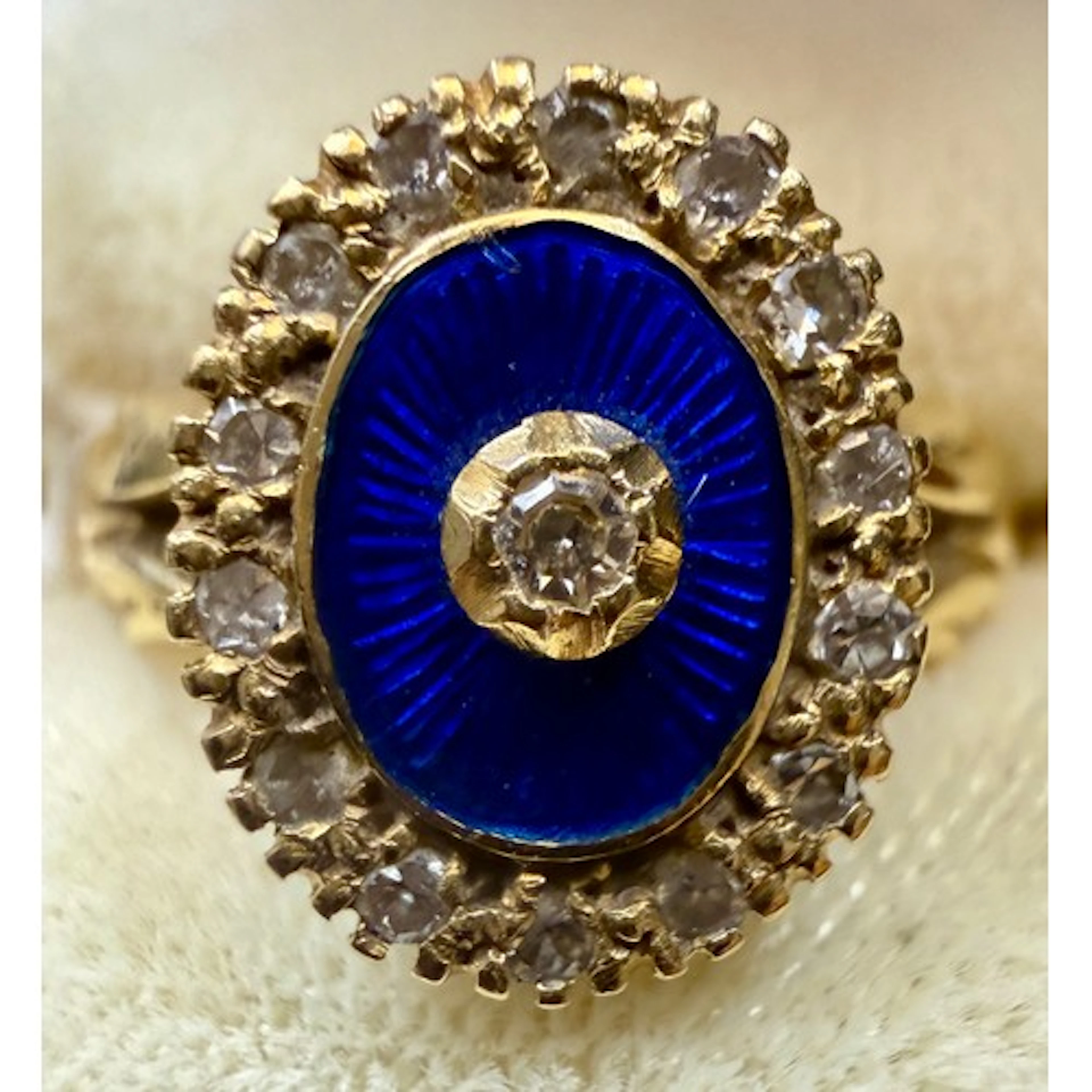 An 18 carat gold ring set with diamonds and blue enamel. Siz...