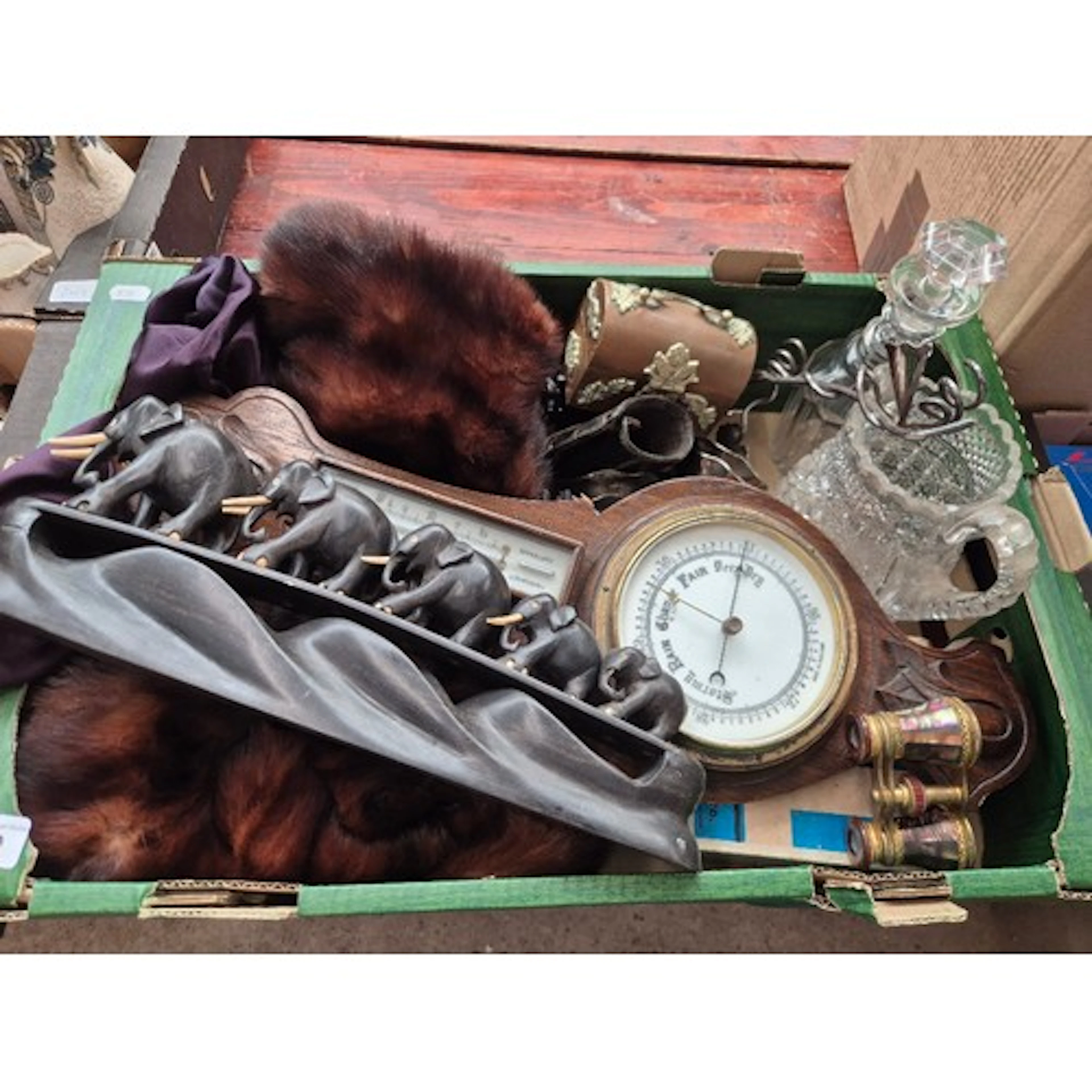 A box of mixed items to include barometer, carved elephants,...