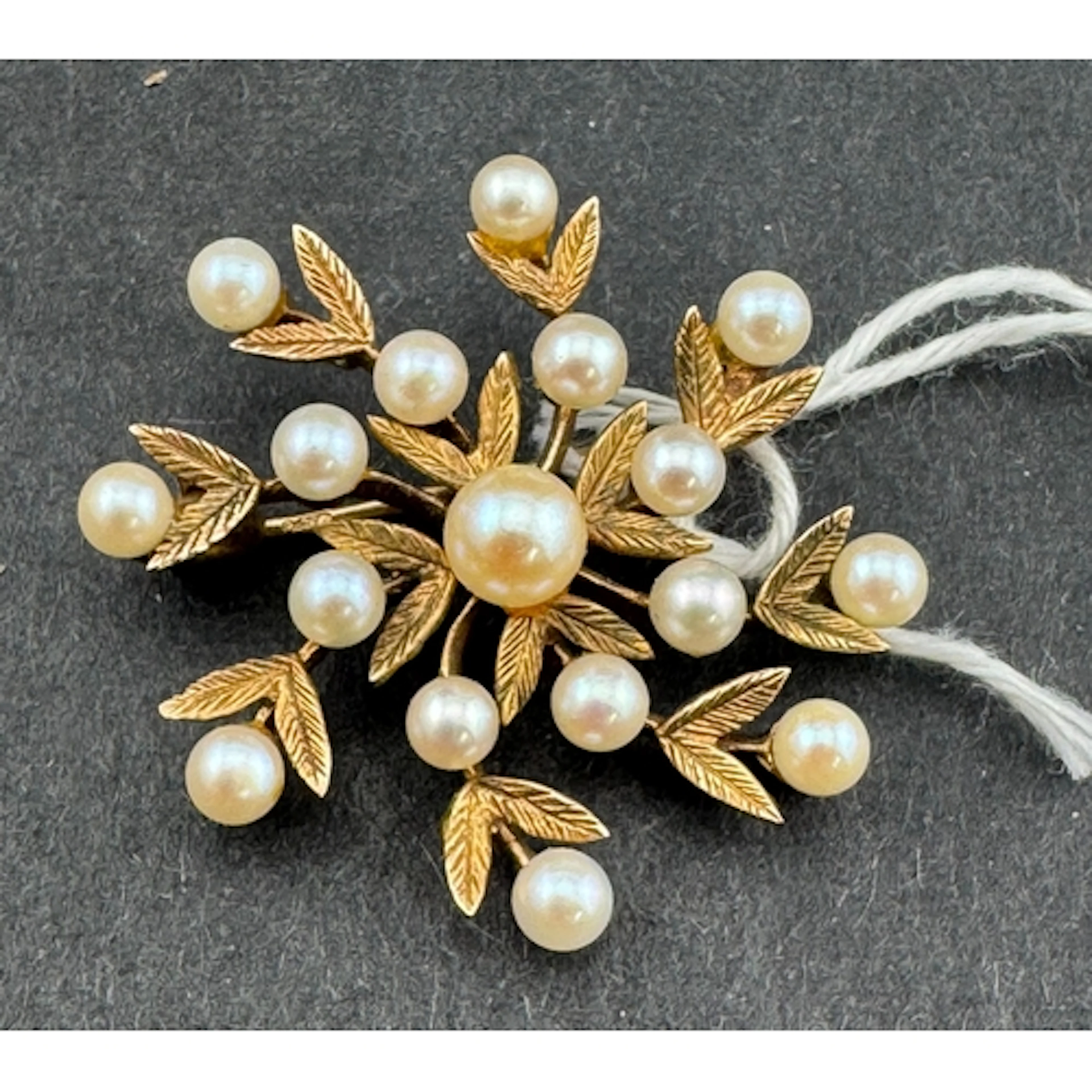 Jewellery: a 9ct gold mistletoe style brooch, a central pear...