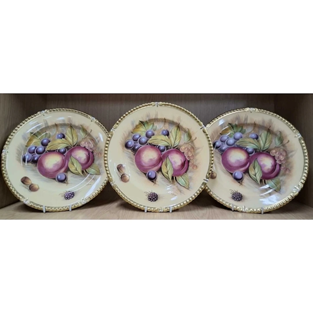 THREE AYNSLEY ORCHARD GOLD PLATES, with gilt moulded rims, p...