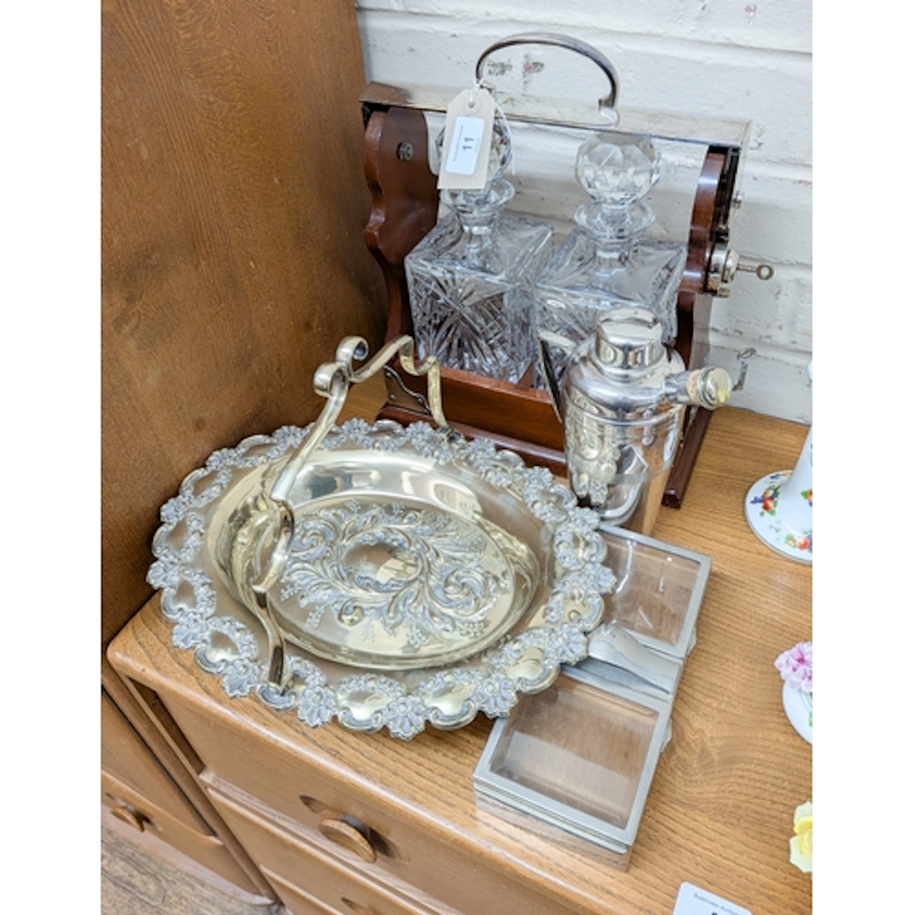 A two bottle spirit tantalus together with a fruit basket, a...