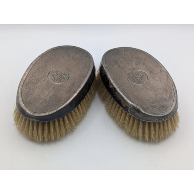 A pair of George V silver backed dressing table brushes by M...
