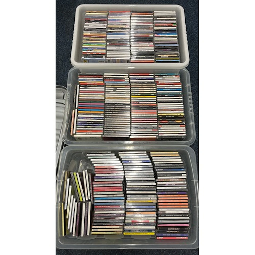 Three boxes containing mixed CDs.