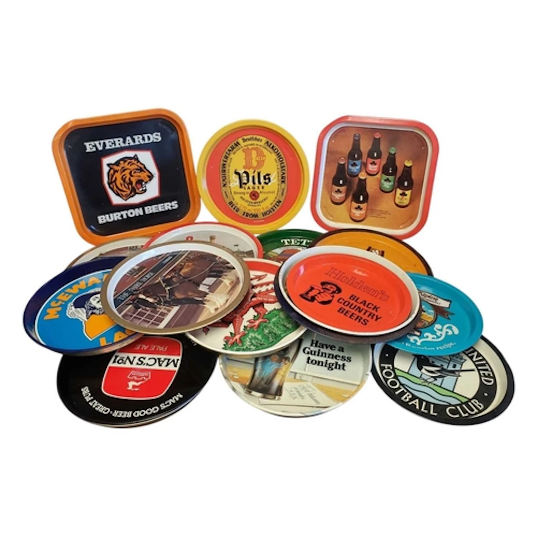 A collection of vintage 20th century metal pub serving trays...