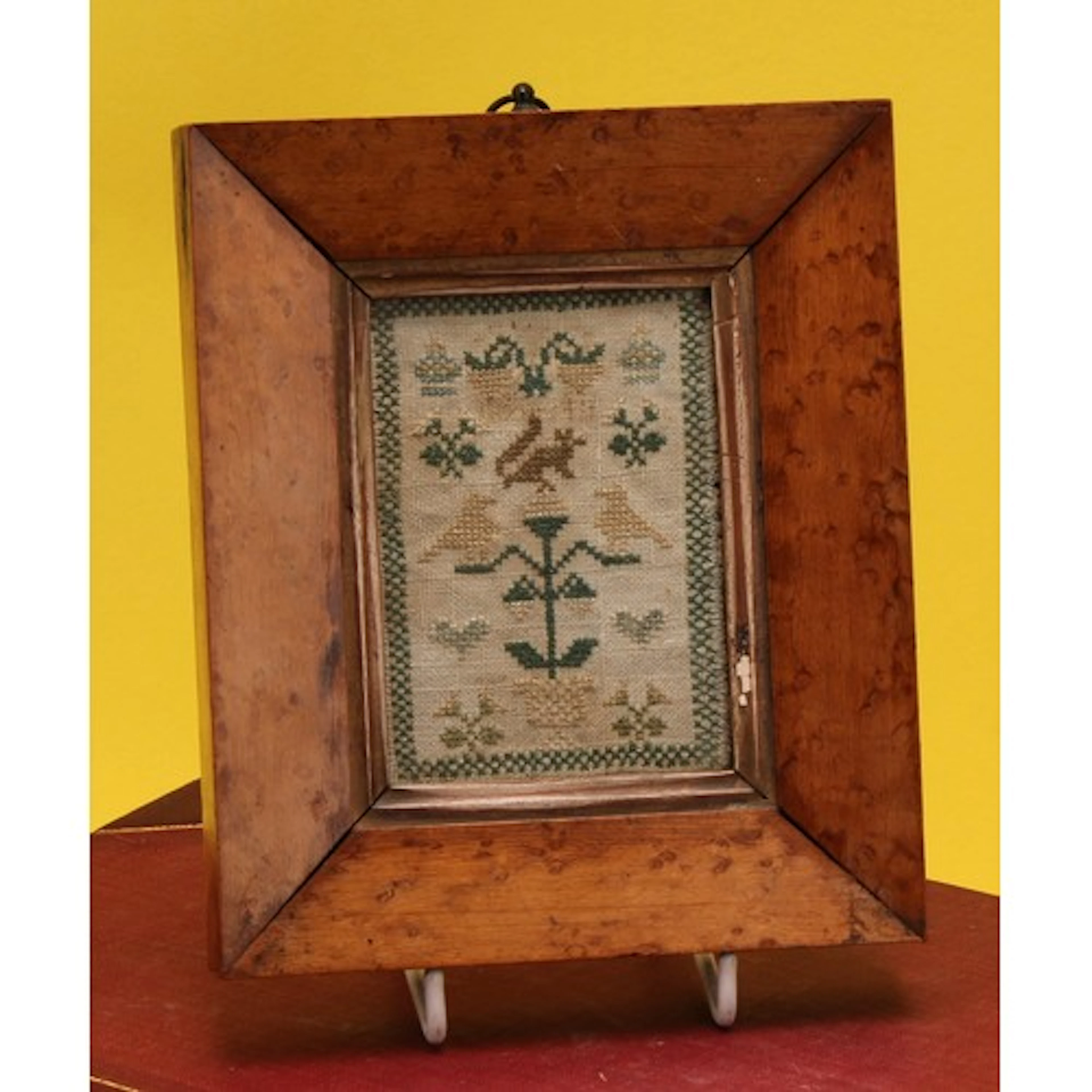 A 19th century miniature needlework sampler, in coloured thr...