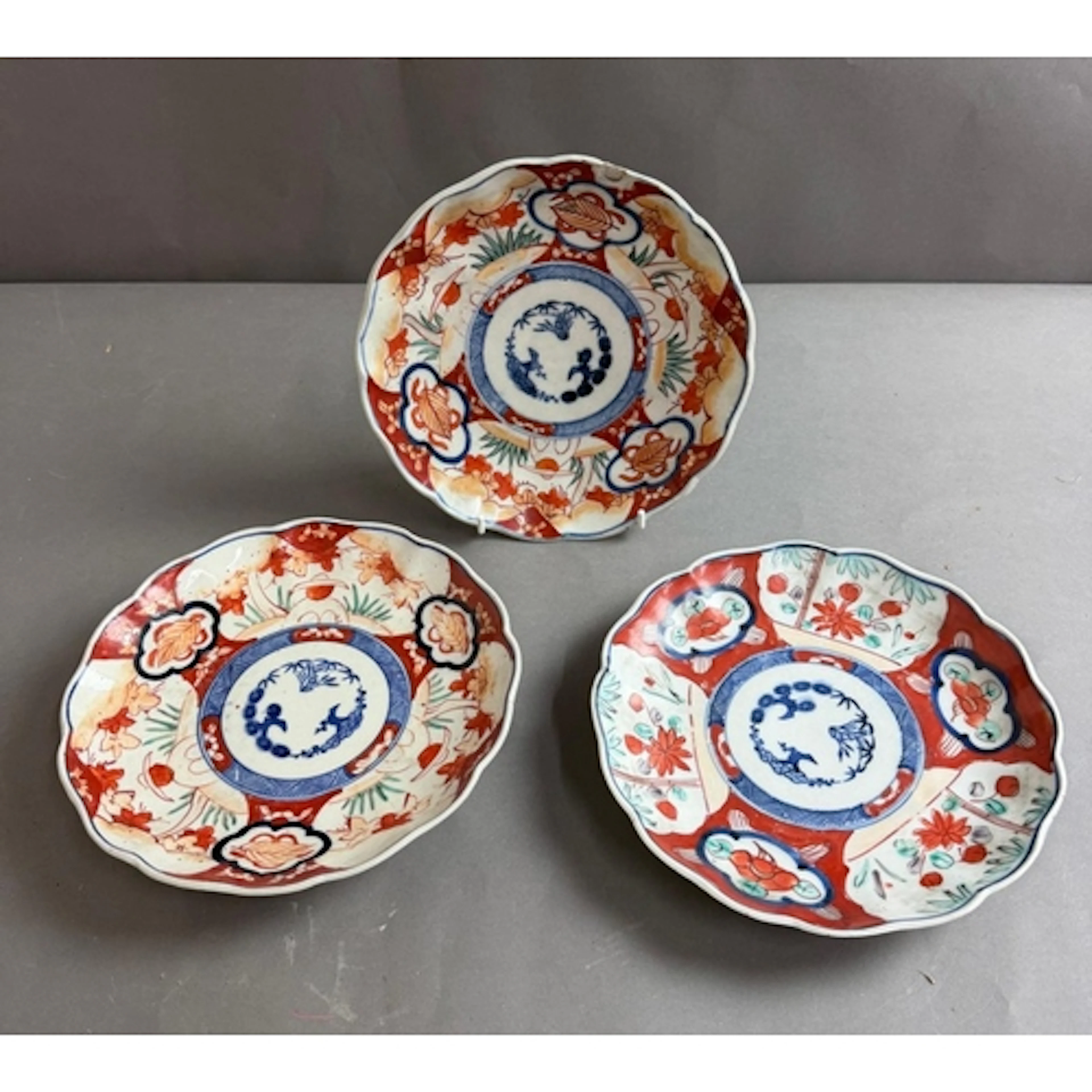 Three Imari porcelain plates with a scalloped wavy rim...