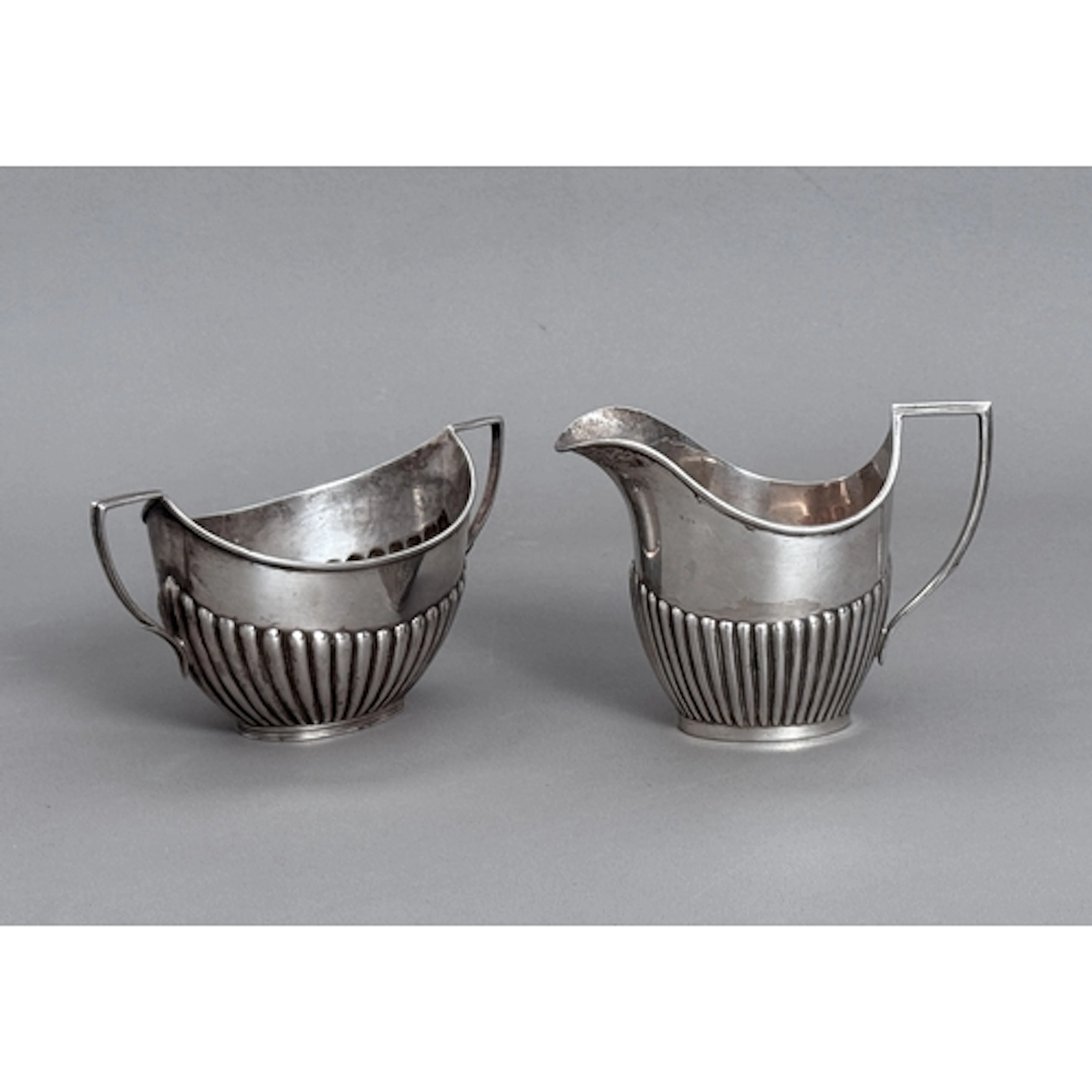A matched silver two handled sugar bowl and cream jug - in t...