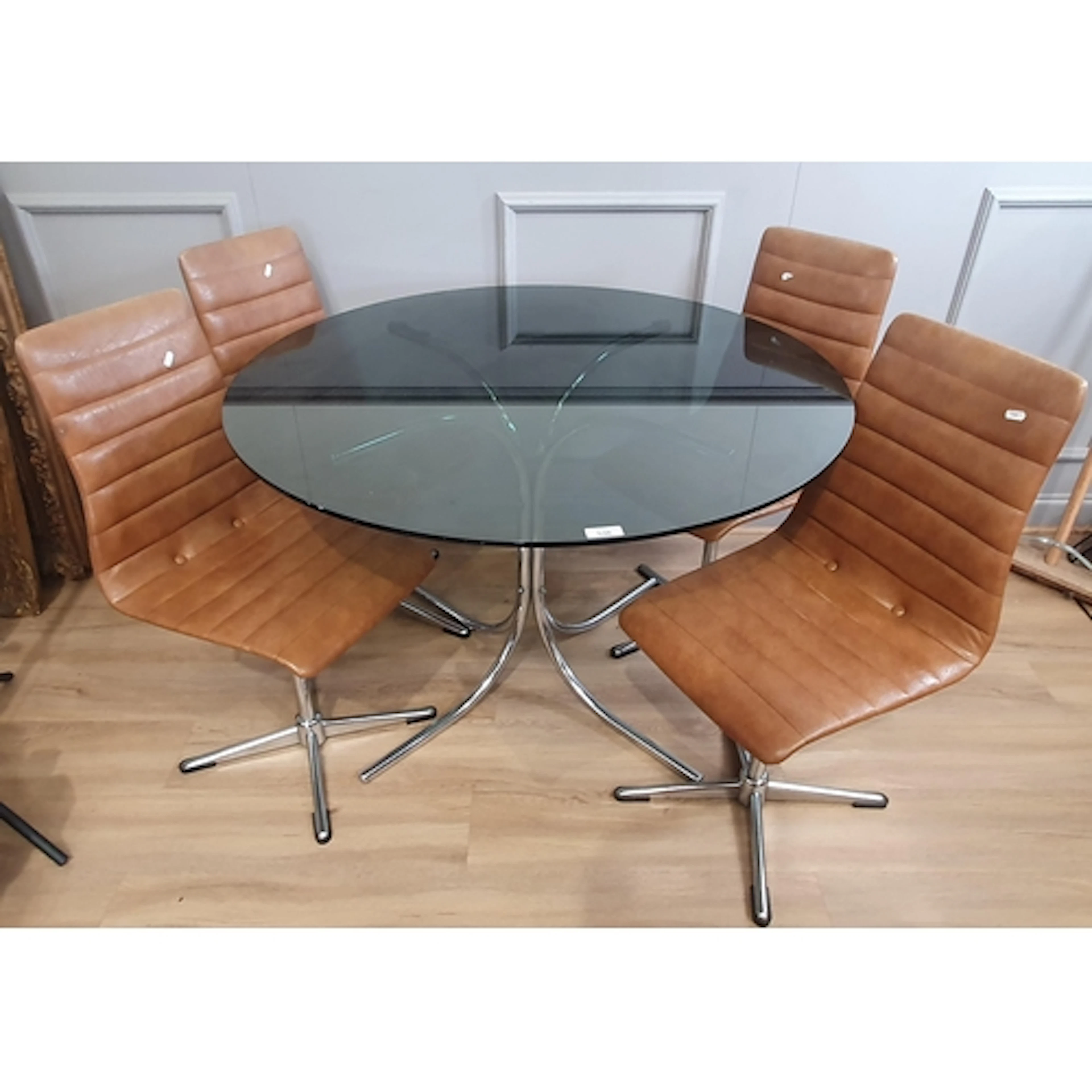 A modern circular glass topped Table on metal base and four ...