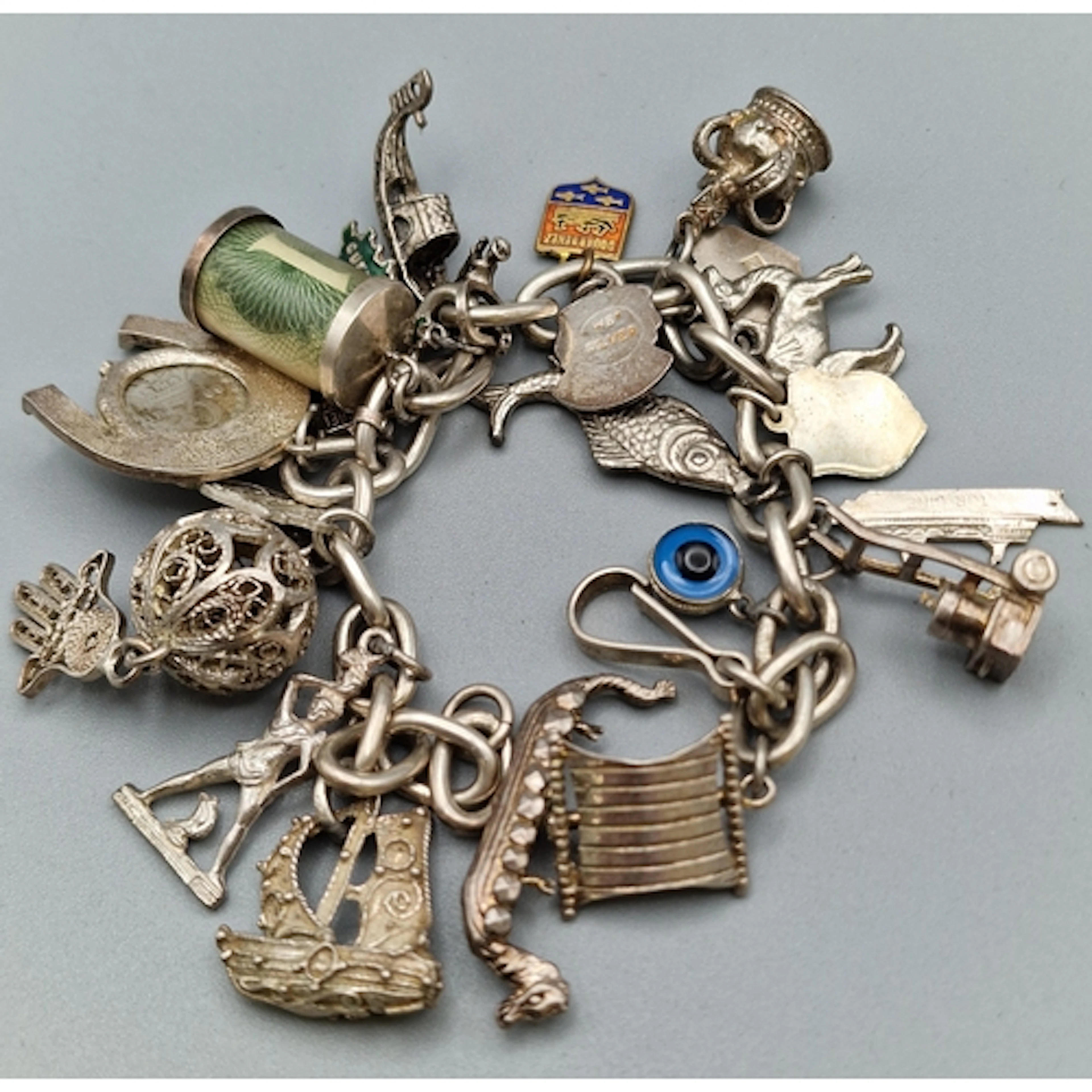 Silver curb-link charm bracelet with assorted enamel and oth...
