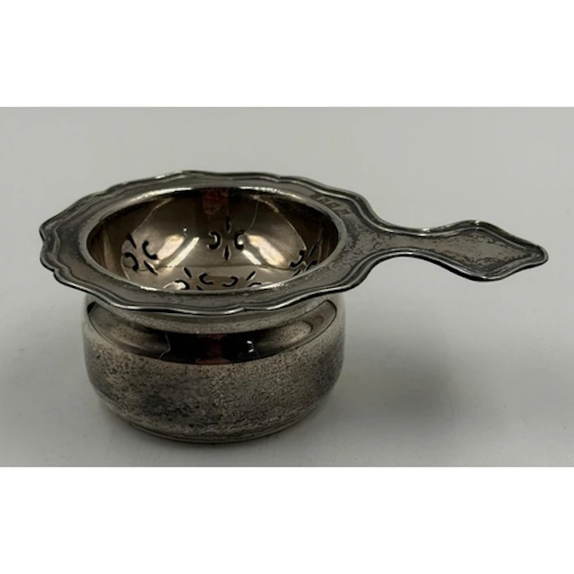 A silver tea strainer set hallmarked for London 1958 by Robe...
