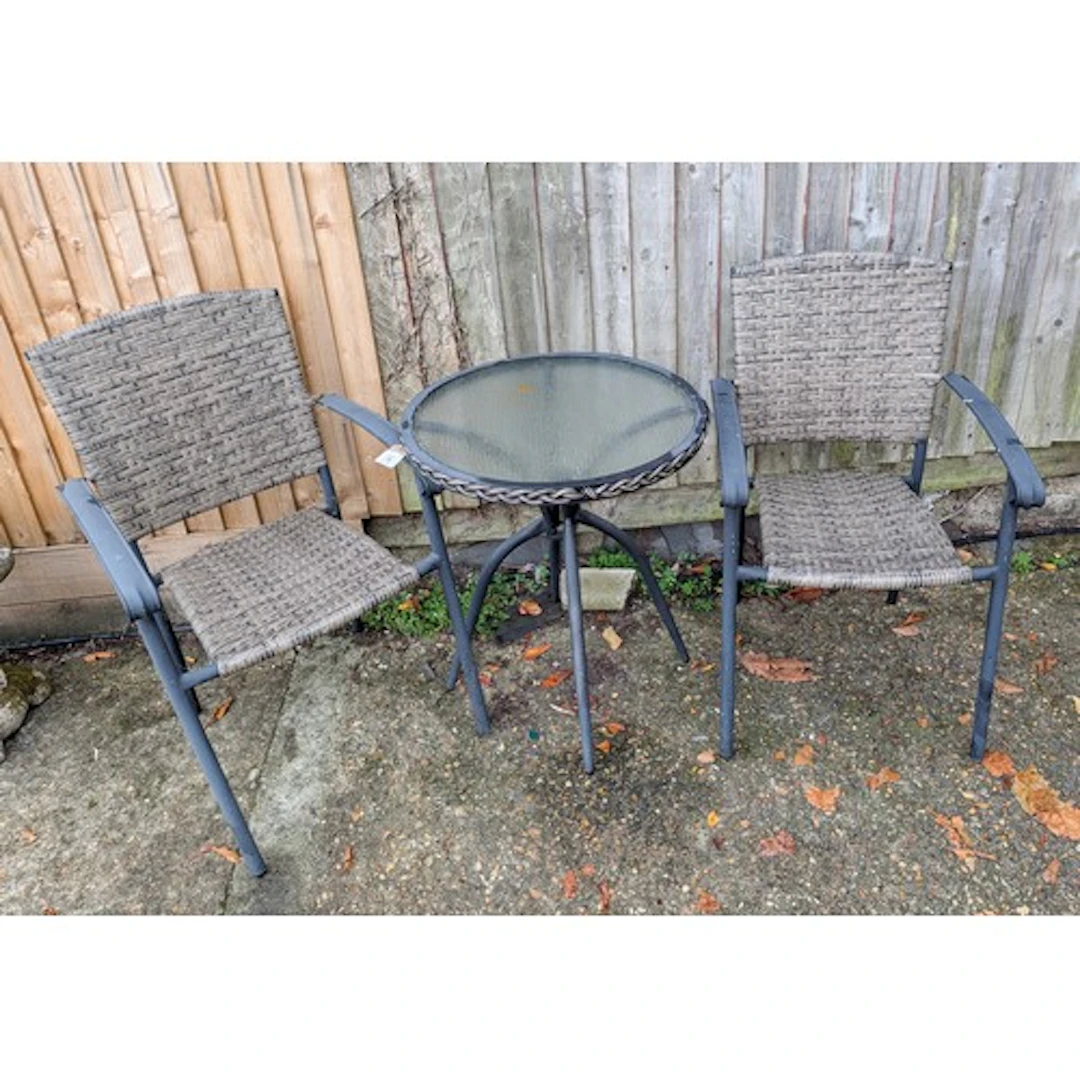 A black chrome framed garden table with inset glass top with...