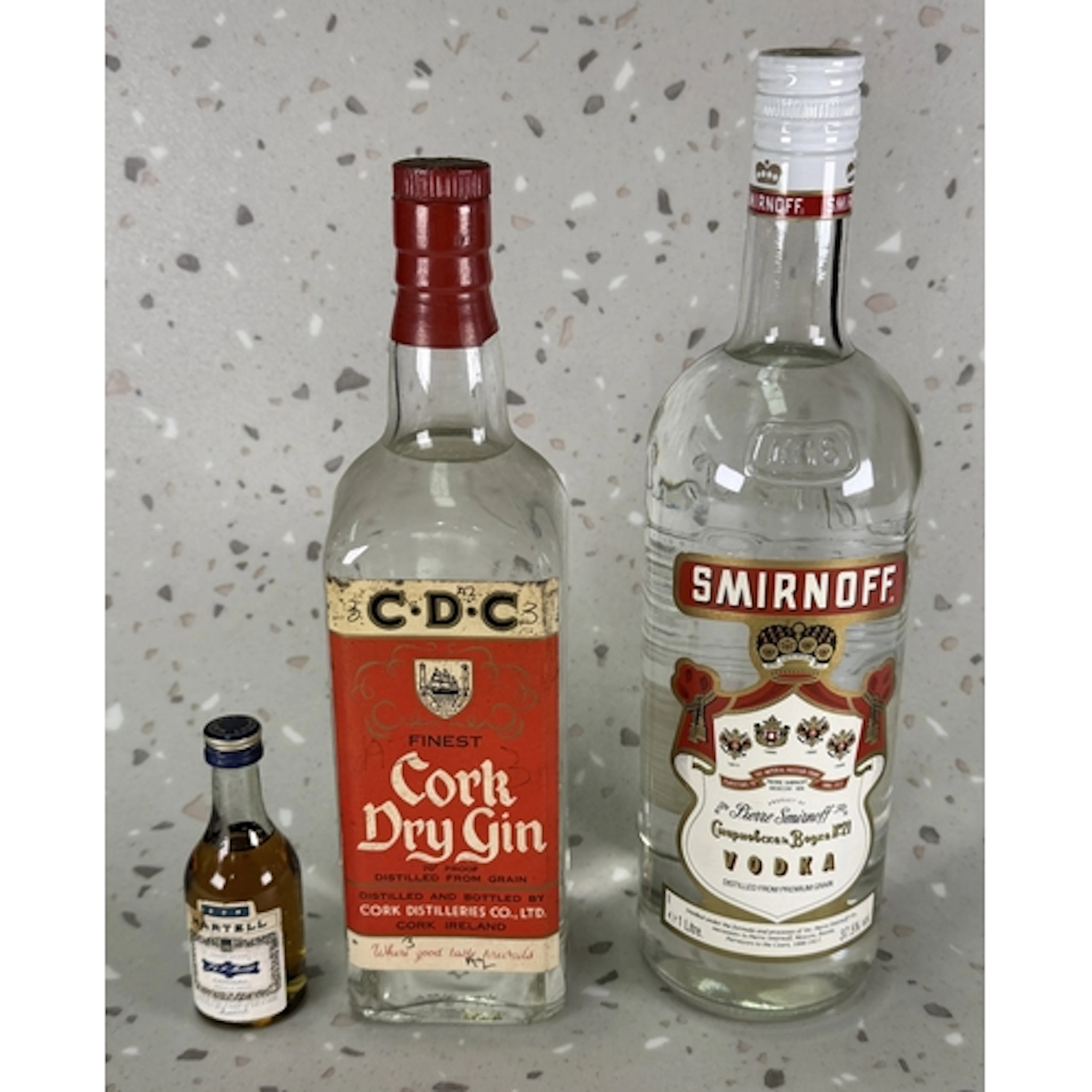 A bottle of Cork Dry Gin, a litre bottle of Smirnoff Vodka a...