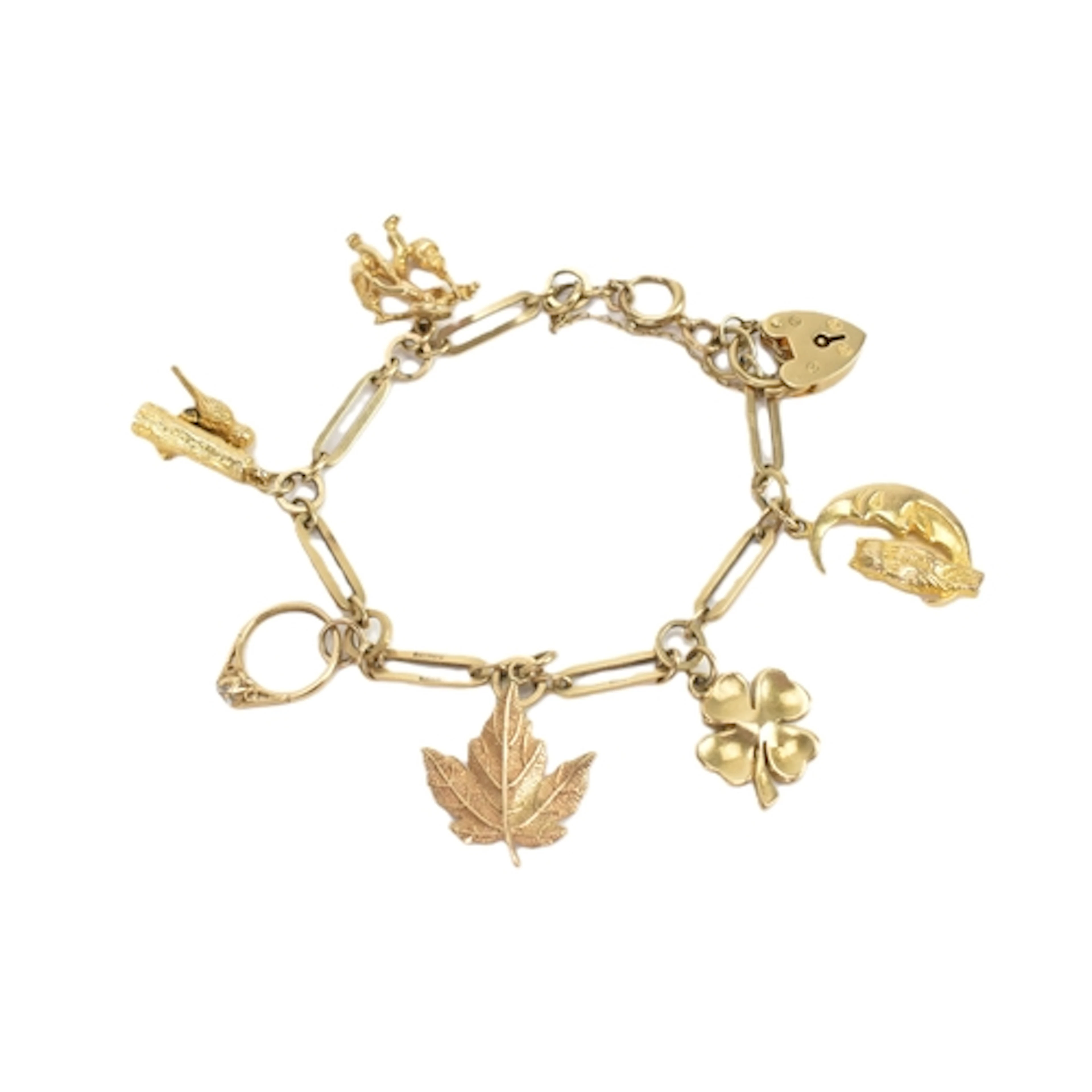 A 9ct gold charm bracelet, fitted with a heart shaped locket...
