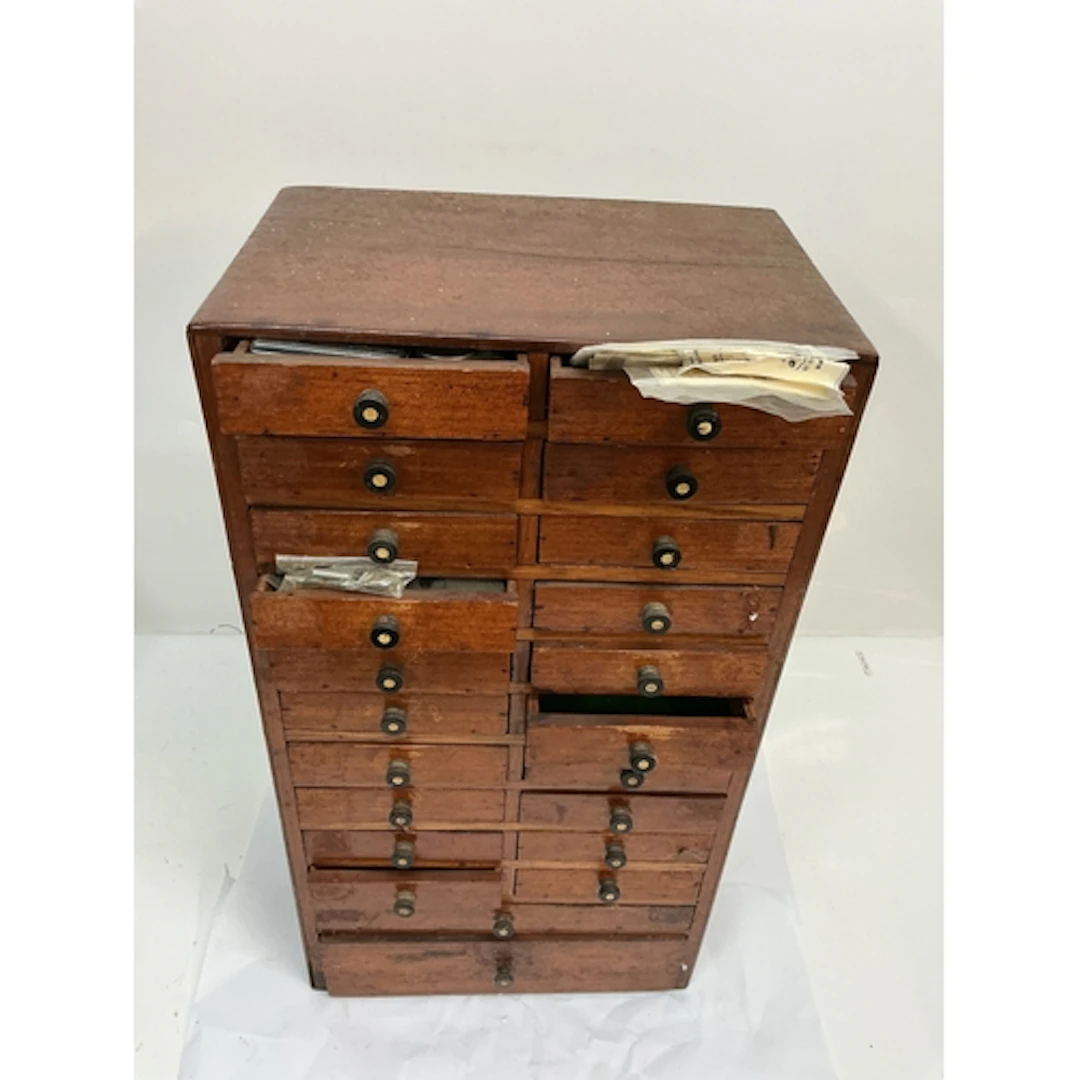 A watch maker’s set of cabinet drawers including some assort...