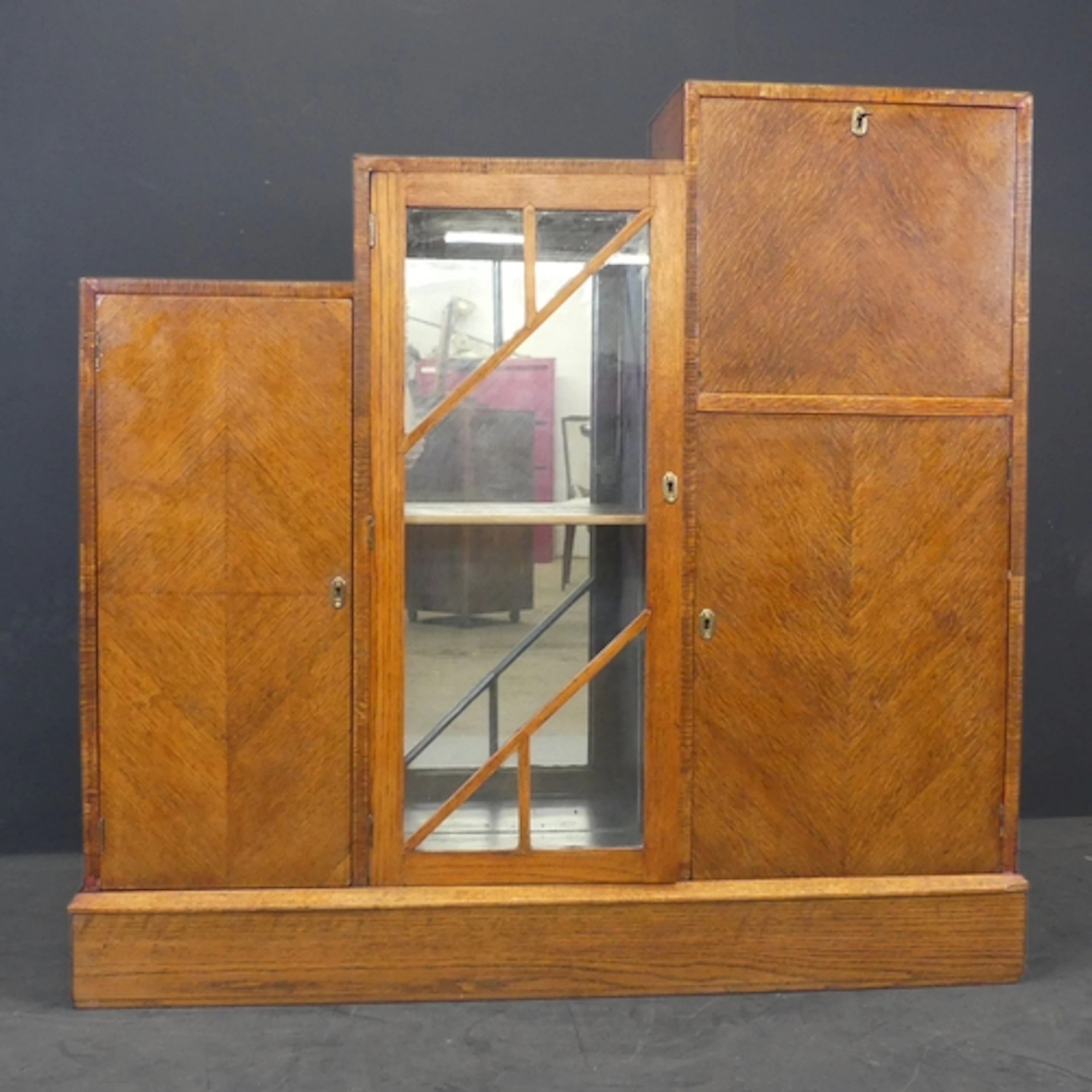 An unusual oak veneered Art Deco cocktail cabinet of stepped...