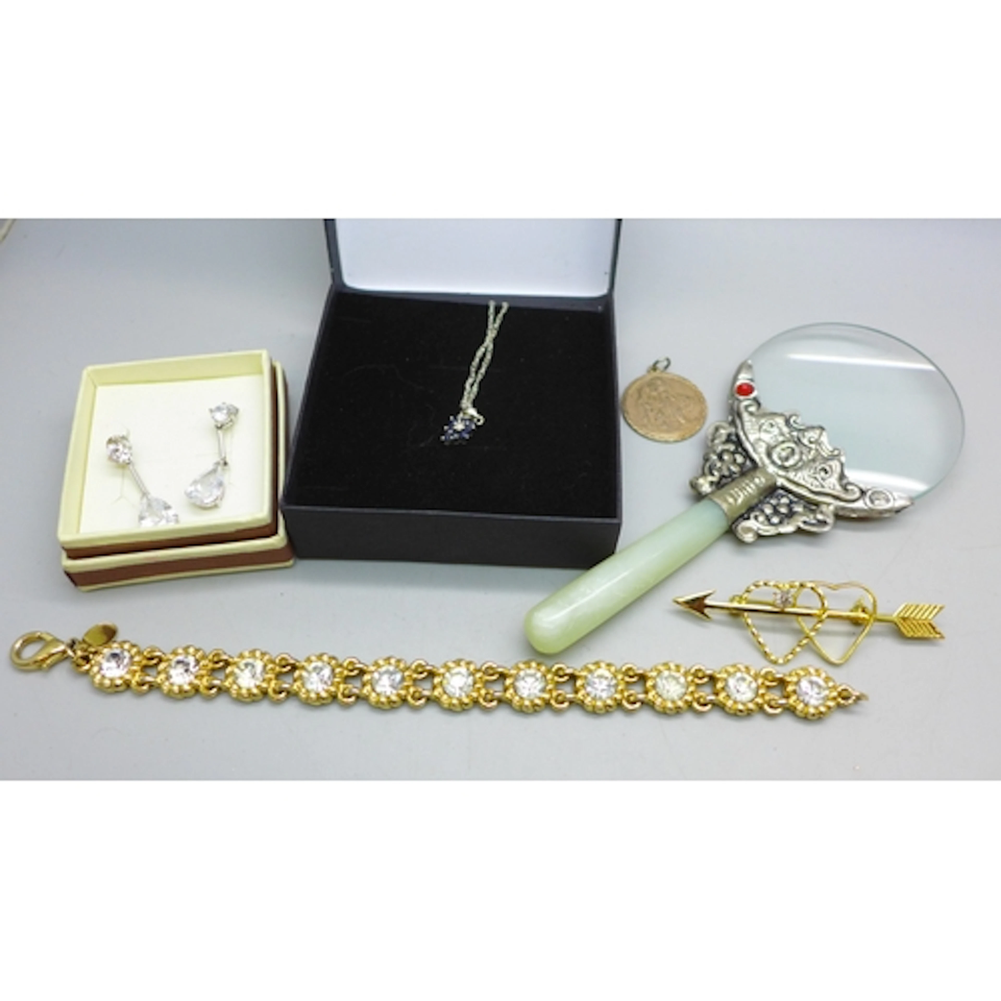 A small 9ct gold sapphire cluster pendant on a silver chain,...
