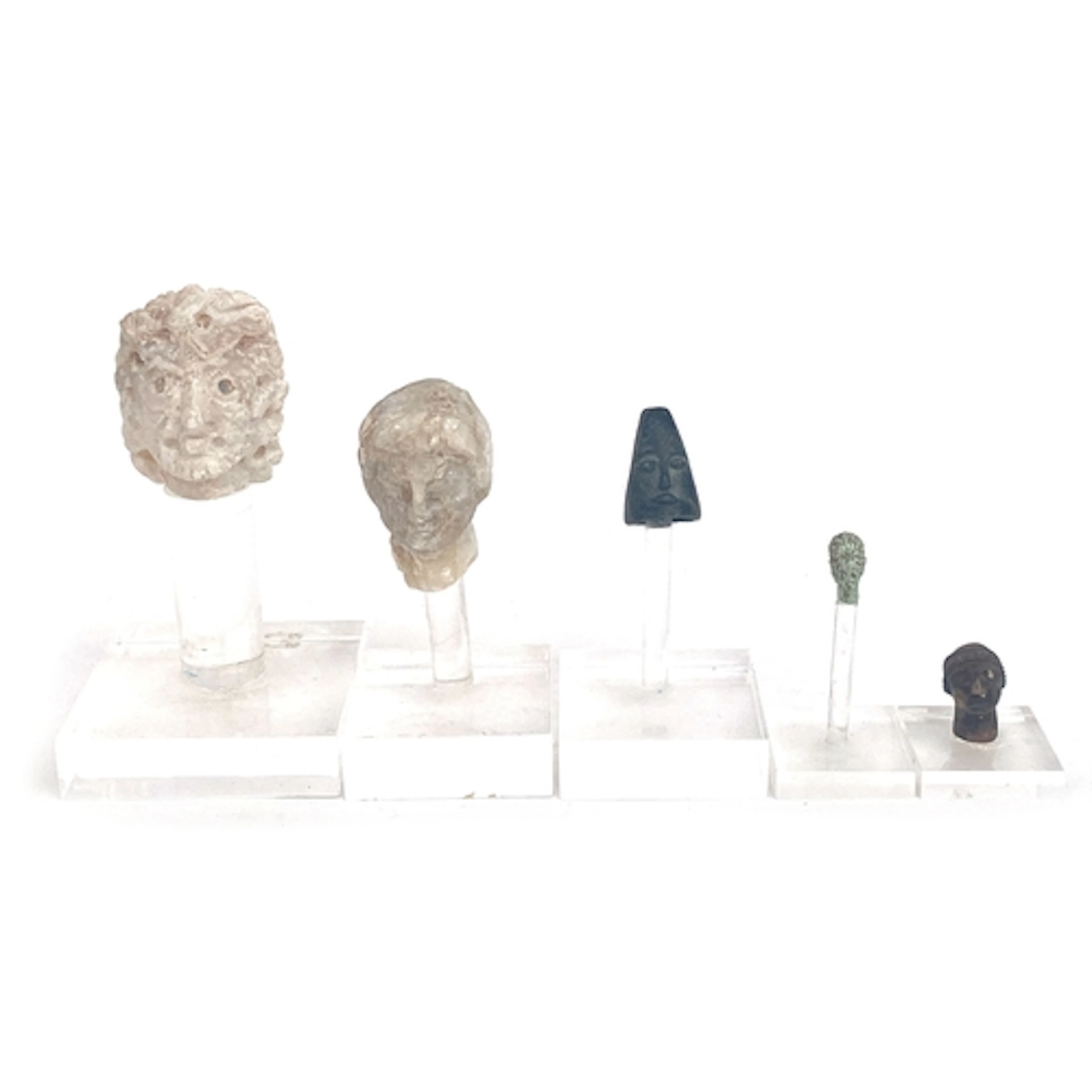 A collection of ancient style carved sculptural heads, two l...